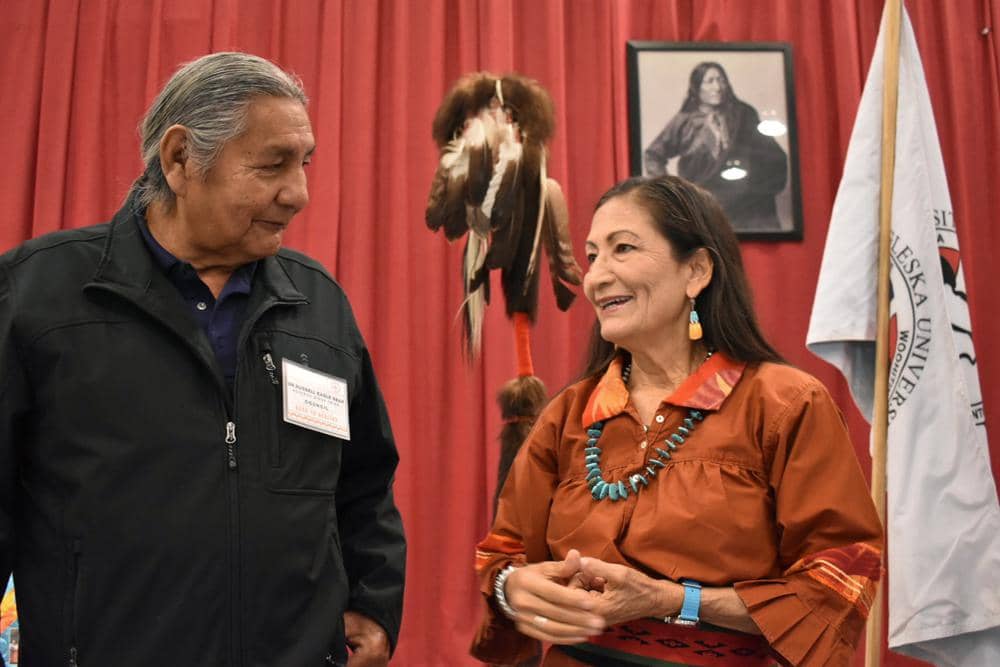 Russell Eagle Bear, with the Rosebud Sioux Reservation Tribal Council, talks to U.S. Interior Secretary Deb Haaland during a meeting about Native American boarding schools at Sinte Gleska University in Mission, S.D., Saturday, Oct. 15, 2022. Haaland has been holding events across the nation to shed light on the abuse suffered by many Native American children forced to attend the government-backed schools. (Credit: Matthew Brown/AP.)