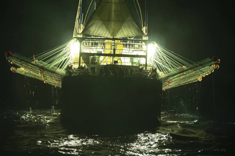 In this July 2021 photo provided by Sea Shepherd, the Chang Tai 802, a Chinese-flagged ship, fishes for squid at night on the high seas off the west coast of South America. Hazardous work conditions sometimes akin to slavery have been detected on nearly 500 industrial fishing vessels around the world, including this one, but identifying those responsible for abuses at sea is hampered by a lack of transparency and regulatory oversight, according to research by the Financial Transparency Coalition released on Wednesday, Nov. 15, 2023. (Credit: Isaac Haslam/Sea Shepherd via AP.)