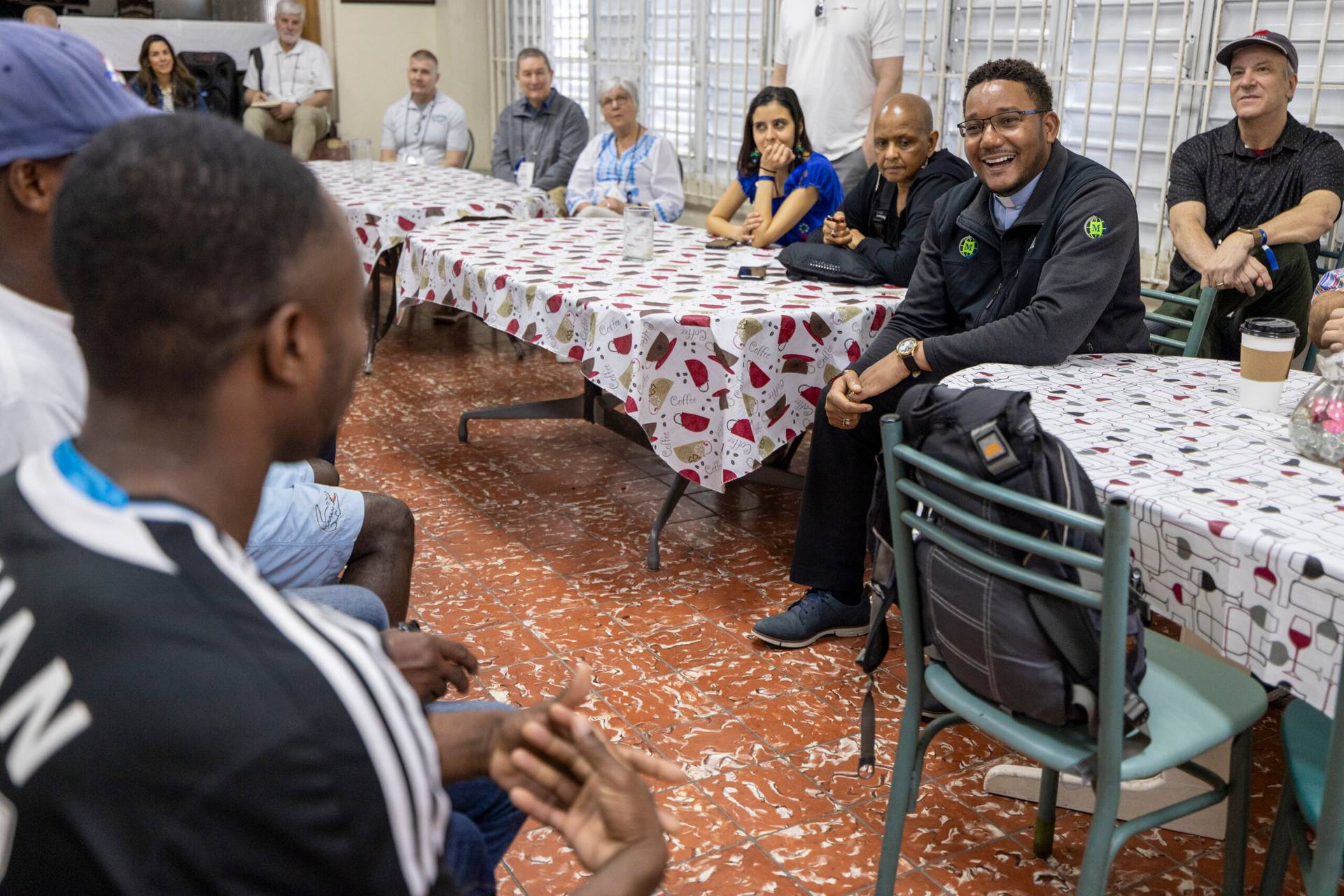 Father Juan Luxama, a priest of the Diocese of Brooklyn, talking with Haitian migrants at San Mateo Church in San Juan while on a Catholic Extension Immersion Trip in February 2024. (Credit: Catholic Extension)