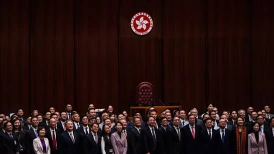 Hong Kong's Chief Executive John Lee, fifth foreground left, pose for photographs with lawmakers following the passing of the Basic Law Article 23 legislation. (Credit: AP Photo.)