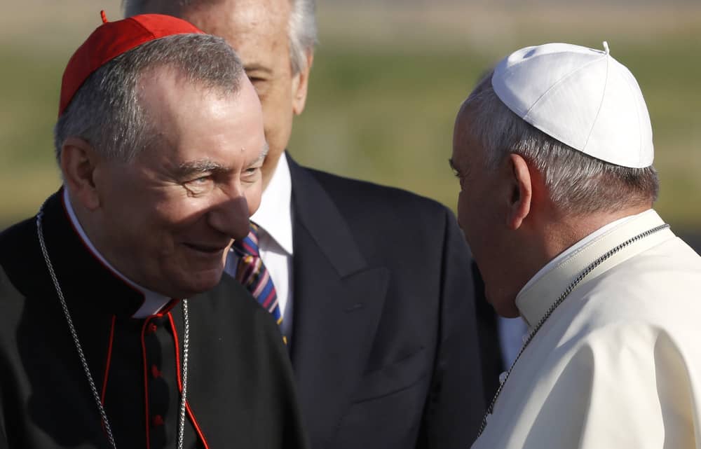 Pope Francis greets Vatican Secretary of State Cardinal Pietro Parolin, left, as he arrives to board a plane to Amman, Jordan, for a three-day trip to the Middle East including the West Bank and Israel, at Rome's Fiumicino international airport, Saturday, May 24, 2014. (Credit: Riccardo De Luca/AP.)