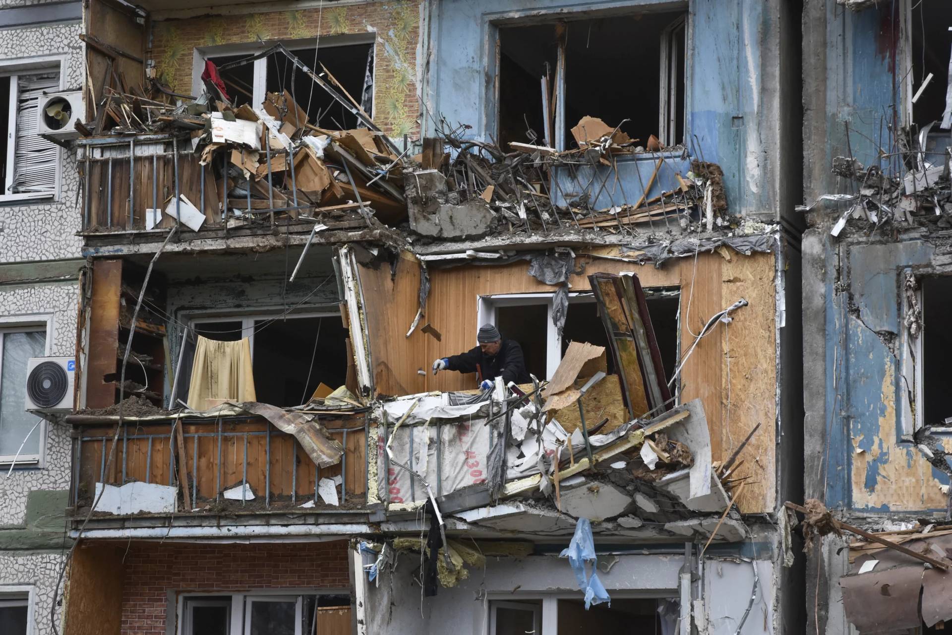People clear the debris in their apartments at the site of Russia's attack in Zaporizhzhia, Ukraine, March 22, 2024. (Credit: Andriy Andriyenko/AP.)
