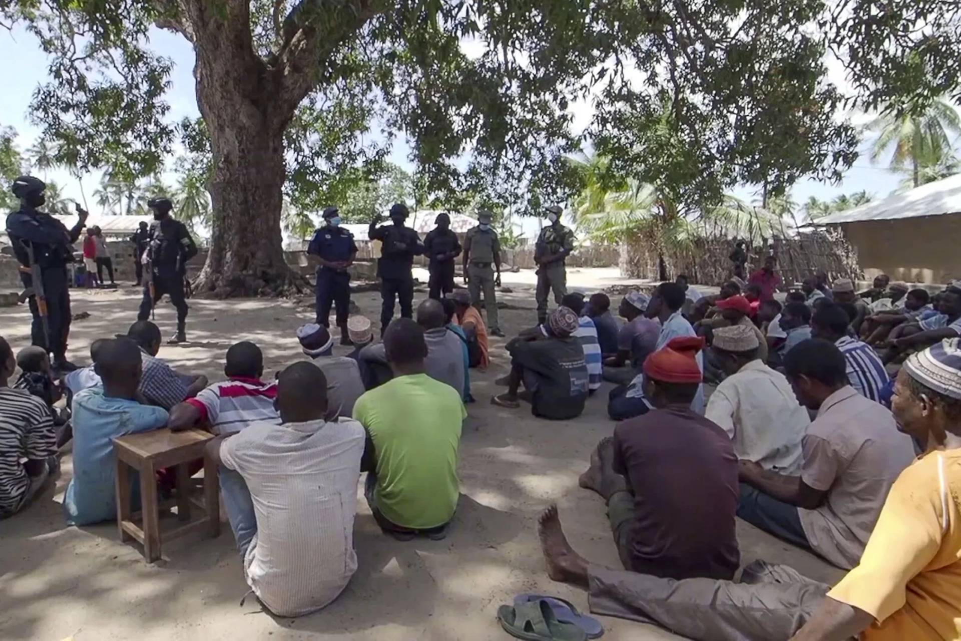 In this image made from video, Rwandan and Mozambican police speak to returnees in Palma, Cabo Delgado province, Mozambique Sunday, Aug. 15, 2021. A surge of new attacks by an Islamic State-affiliated group in Mozambique’s Cabo Delgado province has left more than 70 children missing, with fears they may have drowned in a river or been kidnapped by militants as thousands of families fled the violence, local authorities and a group of aid agencies said. (Credit: Marc Hoogsteyns/AP.)