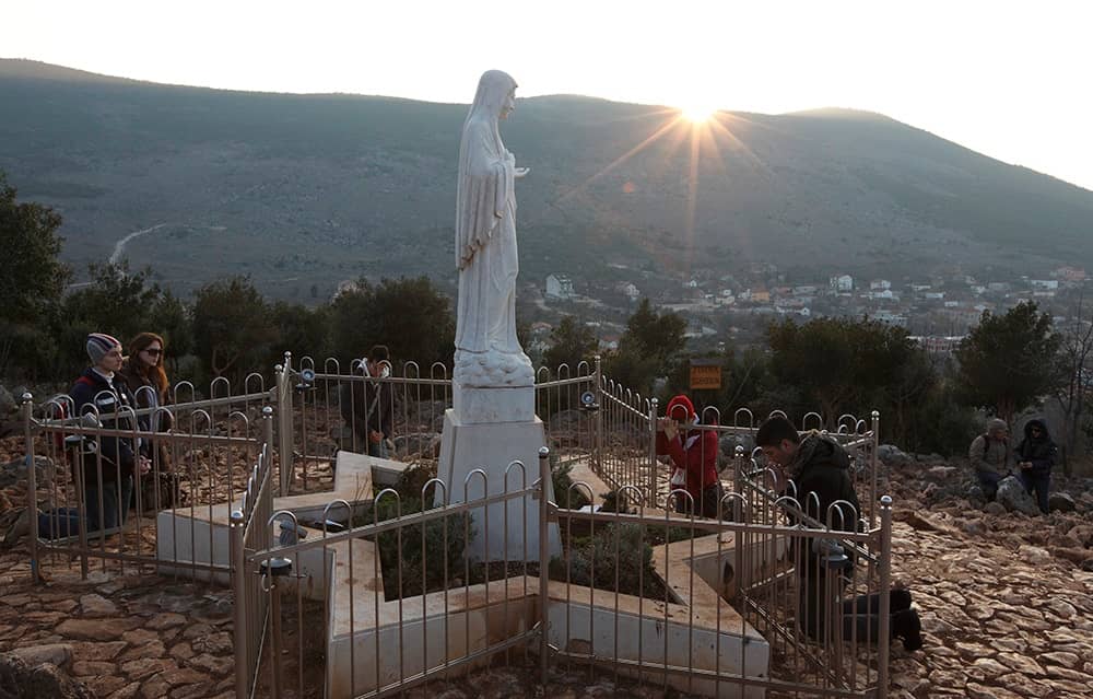 Pilgrims pray around a statue of Mary on Apparition Hill in Medjugorje, Bosnia-Herzegovina, in this 2011 file photo. (Credit: Paul Haring/CNS.)