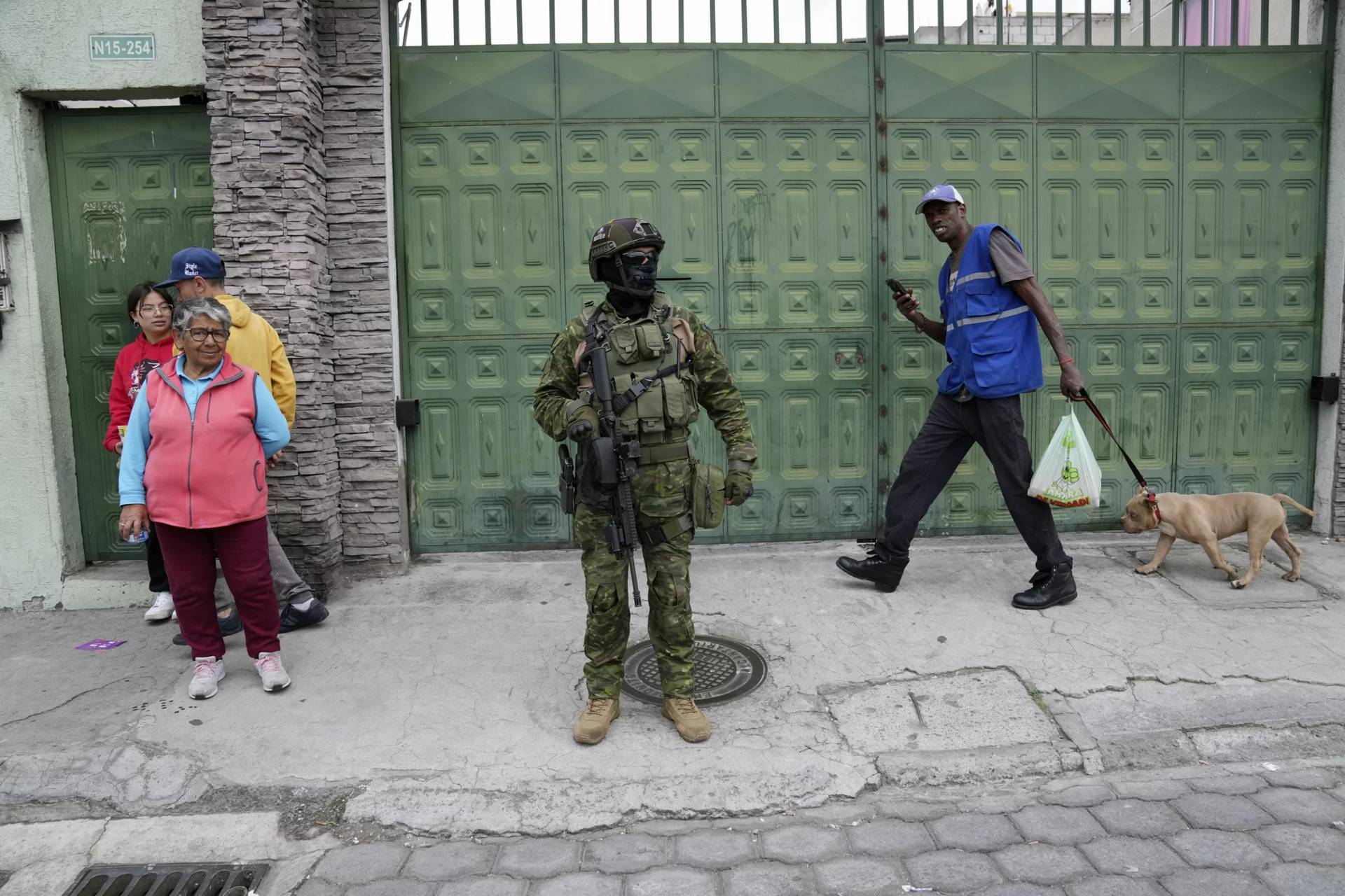 A soldier stands amid pedestrians as his military group patrols a residential area of northern Quito, Ecuador, on Jan. 11, 2024. (Credit: Dolores Ochoa/AP.)