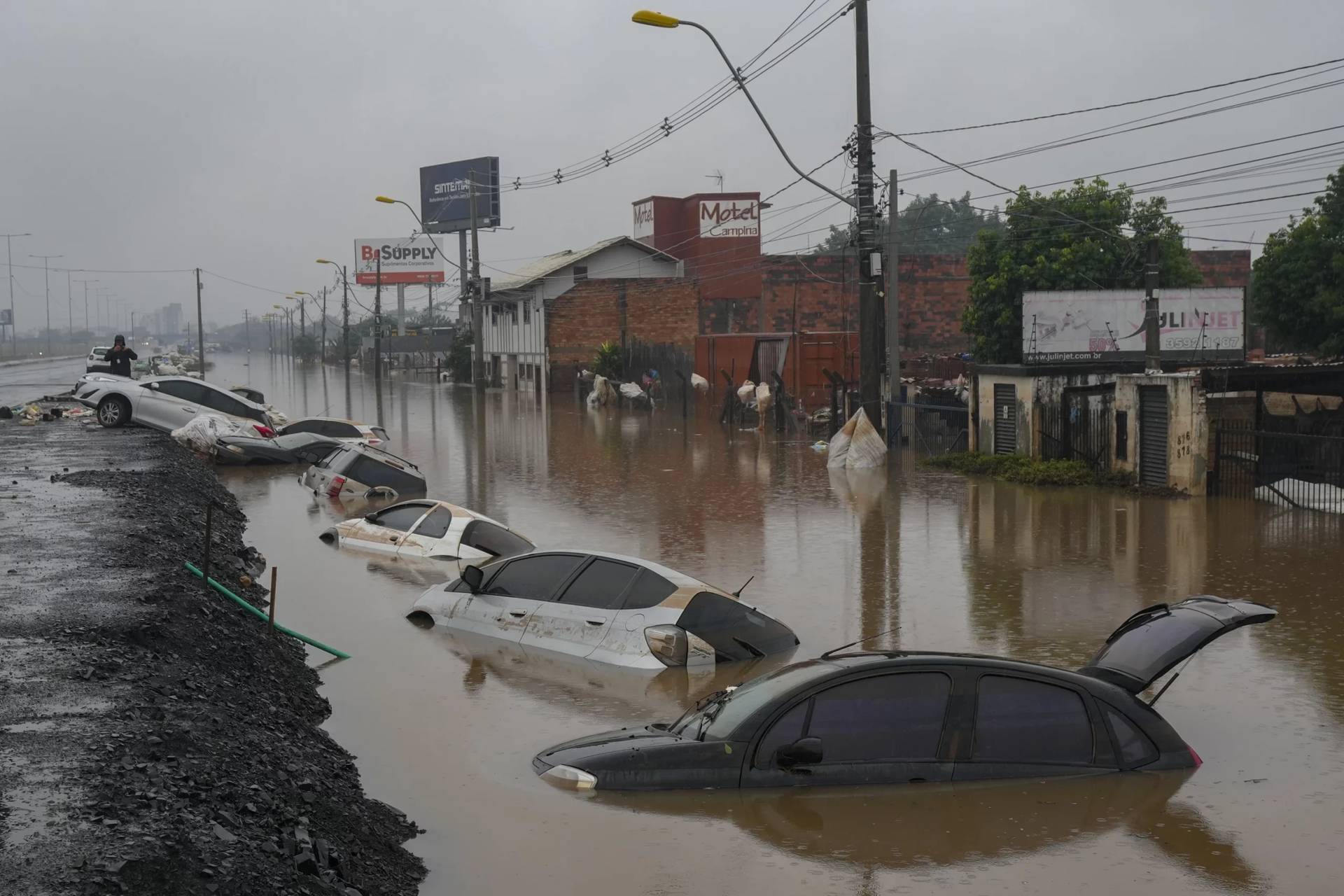 Vehicles are partially submerged on a street flooded by heavy rains in Sao Leopoldo, Rio Grande do Sul state, Brazil, May 11, 2024. (Credit: Andre Penner/AP.)