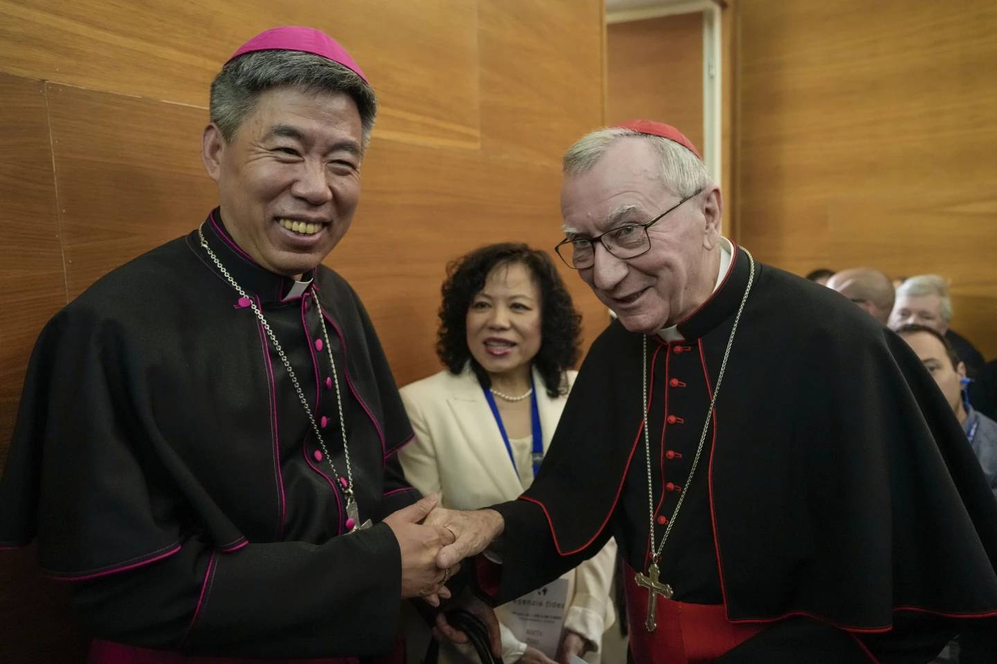 Shanghai Bishop Joeseph Shen Bin, left, shakes hands with Vatican Secretary of State, Cardinal Pietro Parolin, during an international conference to celebrate "100 years since the Concilium Sinese: Between history and the present," celebrating the First Council of the Catholic Church in China, organized by the Pontifical Urbaniana University in Rome on Tuesday, May 21, 2024. (Credit: Andrew Medichini/AP.)