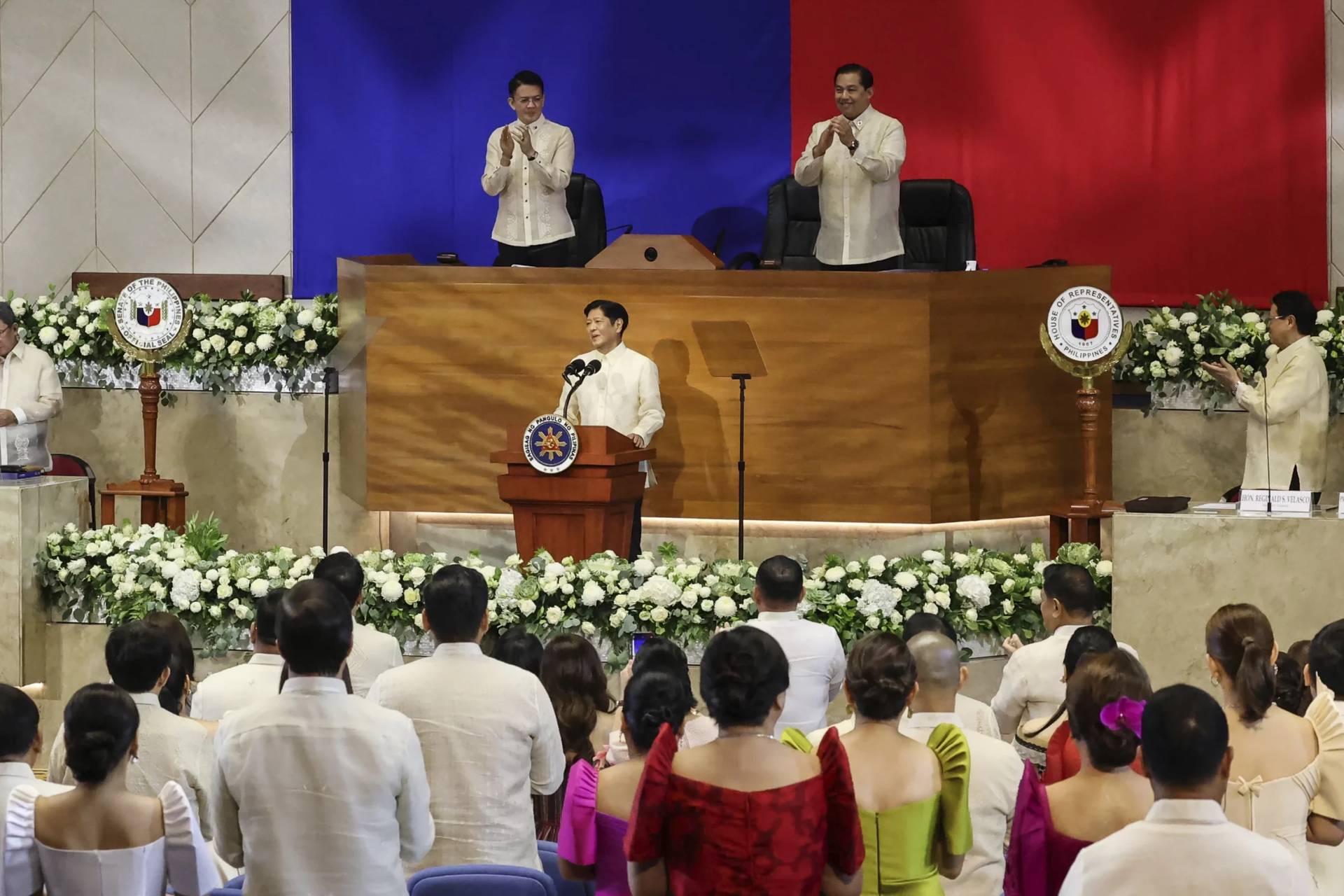 Philippines President Ferdinand Marcos Jr. center, receives a standing ovation during his third State of the Nation Address as Senate President Francis Escudero, top left and House Speaker Martin Romualdez, top right look on at the House of Representatives in Quezon City, Philippines, on Monday, July 22, 2024. (Credit: Gerard V. Carreon/AP.)