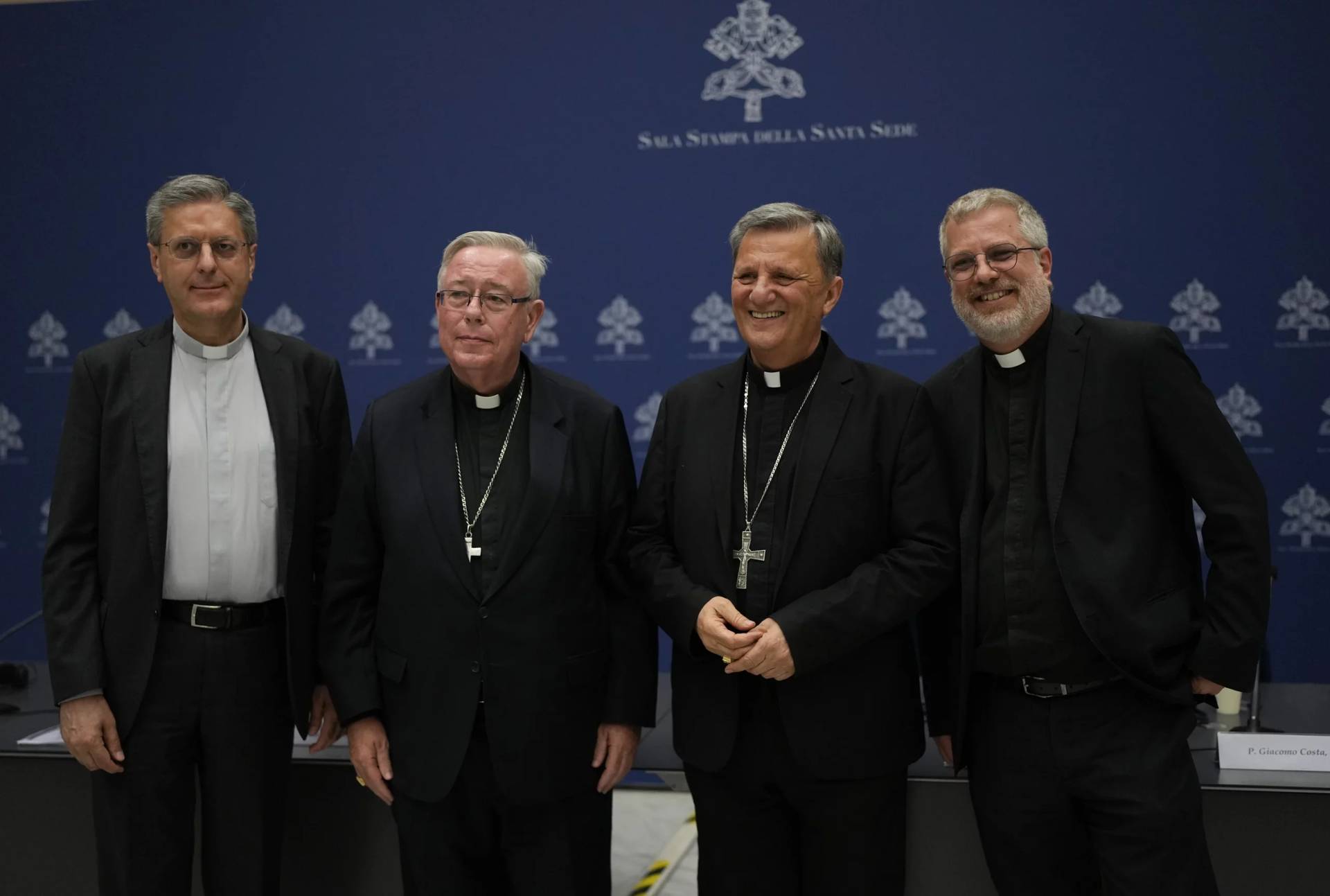 From left, Monsignor Riccardo Batocchio, Cardinal Jean-Claude Hollerich, Cardinal Mario Grech and Father Giacomo Costa pose for a photo after a press conference to present the “Instrumentum Laboris”, a preparatory document in view of the 16th Ordinary General Assembly of the Synod of Bishops, at the Vatican,Tuesday, July 9, 2024. (Credit: Alessandra Tarantino/AP.)