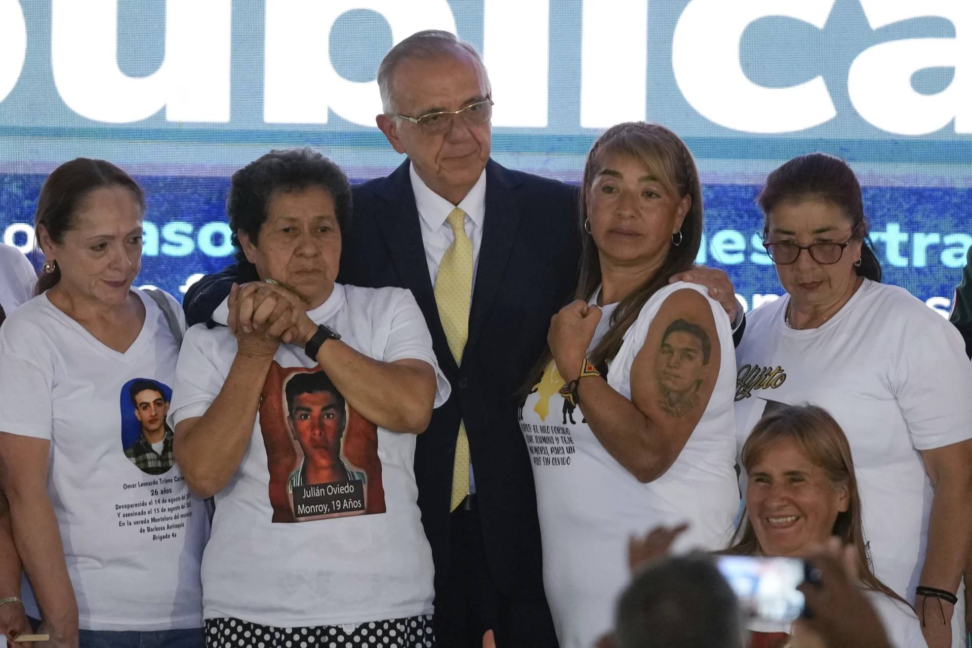 Colombia’s Defense Minister Ivan Velasquez, center, stands with the relatives of 19 young people who were falsely presented as guerrillas killed in combat by the Colombian army during the country’s internal conflict, during an act of recognition and public apology by the state for their extrajudicial execution, in Bogota, Colombia, Tuesday, Oct. 3, 2023. (Fernando Vergara/AP.)