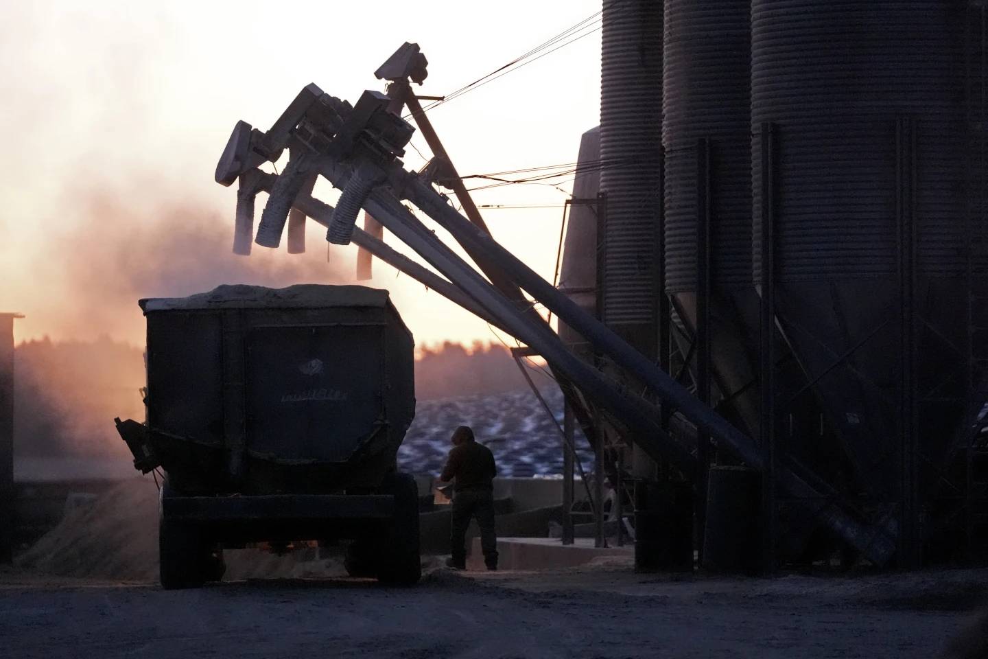 A feed truck is loaded at dawn at the Flood Brothers Farm, Monday, April 1, 2024, in Clinton, Maine. Foreign-born workers make up fully half the farm's staff of nearly 50, feeding the cows, tending crops and helping collect the milk – 18,000 gallons every day. (Credit: Robert Bukaty/AP.)