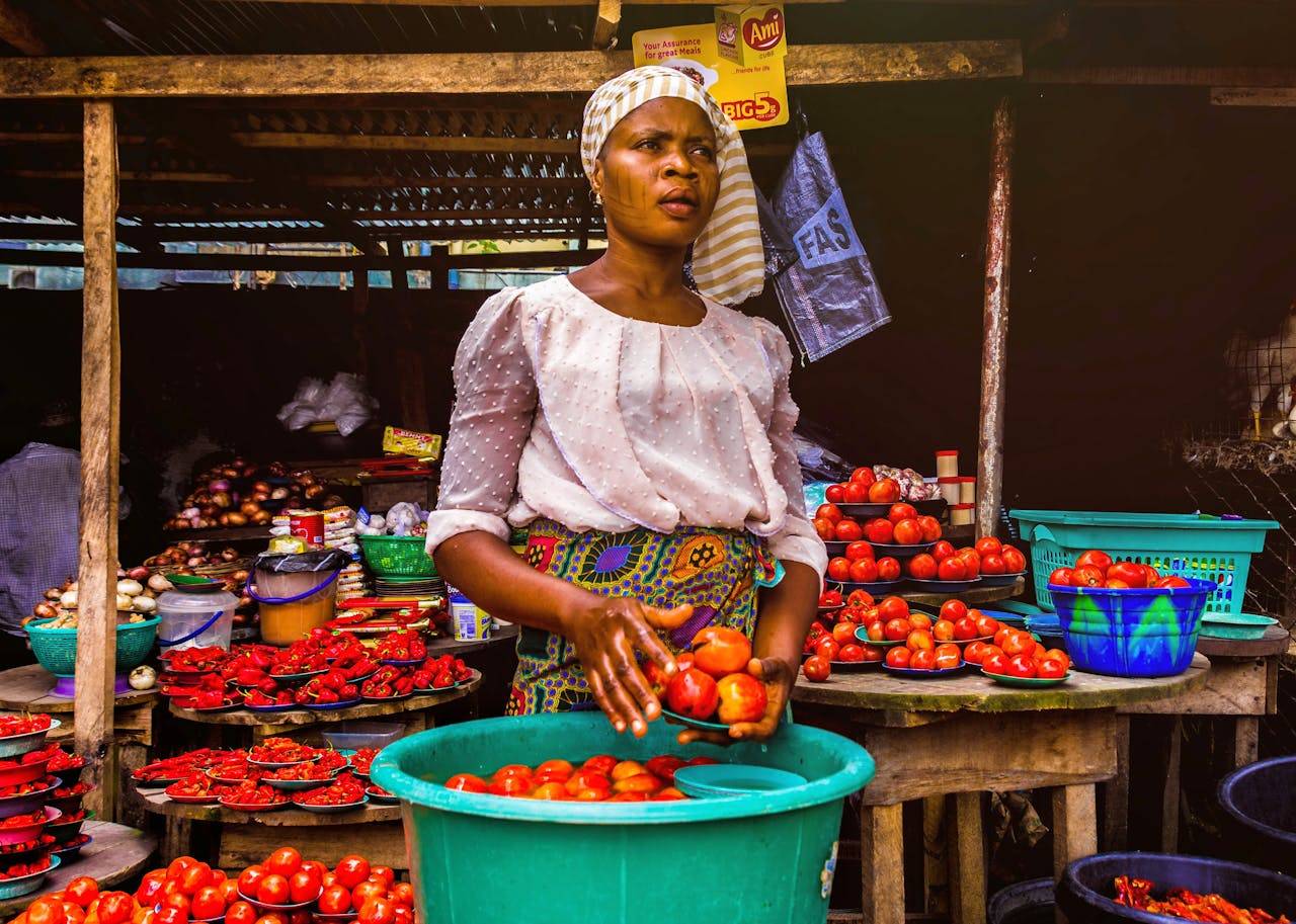 A South African woman sells vegetables. (Credit: Pexels.)