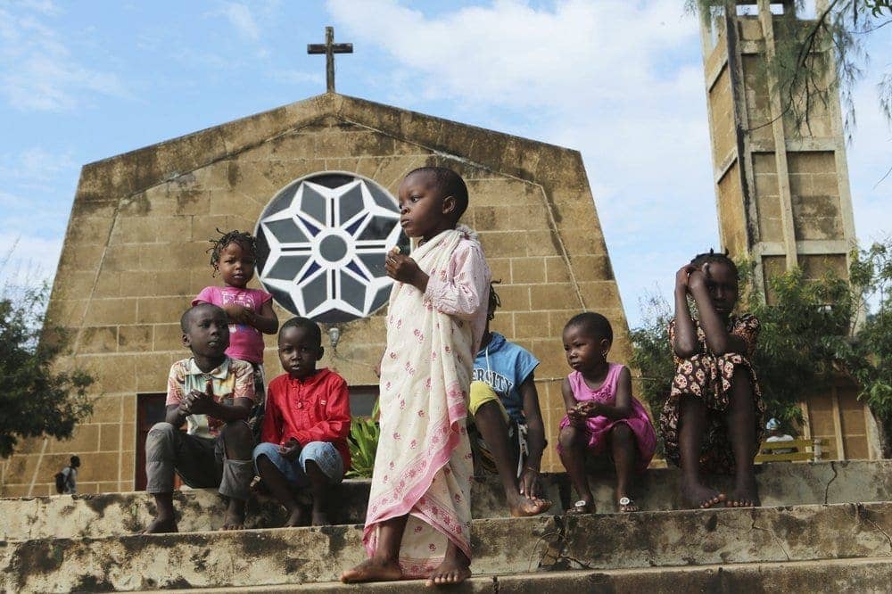 Children relax outside a Catholic church in Pemba city on the northeastern coast of Mozambique in this Monday, April, 29, 2019 photo. (Credit: Tsvangirayi Mukwazhi/AP.)