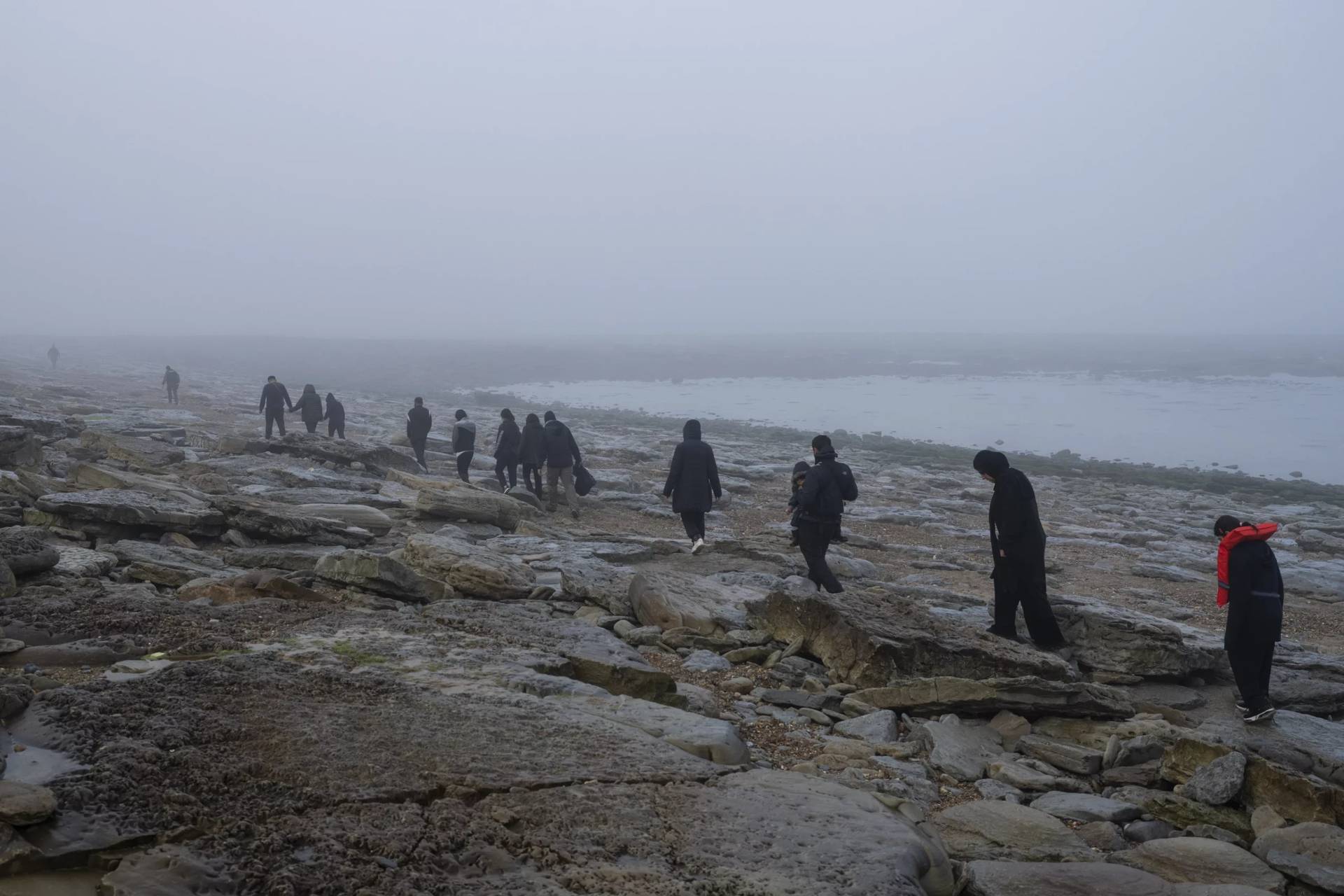 A group of Kurdish migrants from Iran and Iraq who failed in their attempt to reach the United Kingdom by boat walk back to the town of Ambleteuse, northern France, on Sunday, May 19, 2024, after being discovered by the police. (Credit: Bernat Armangue/AP.)