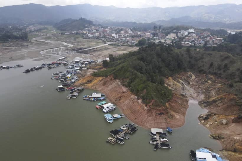 Boats sit docked around the exposed banks of the El Penol-Guatape hydroelectric dam, due to low water levels, in Guatape, Colombia, April 3, 2024. (Credit: Fredy Amariles/AP.)