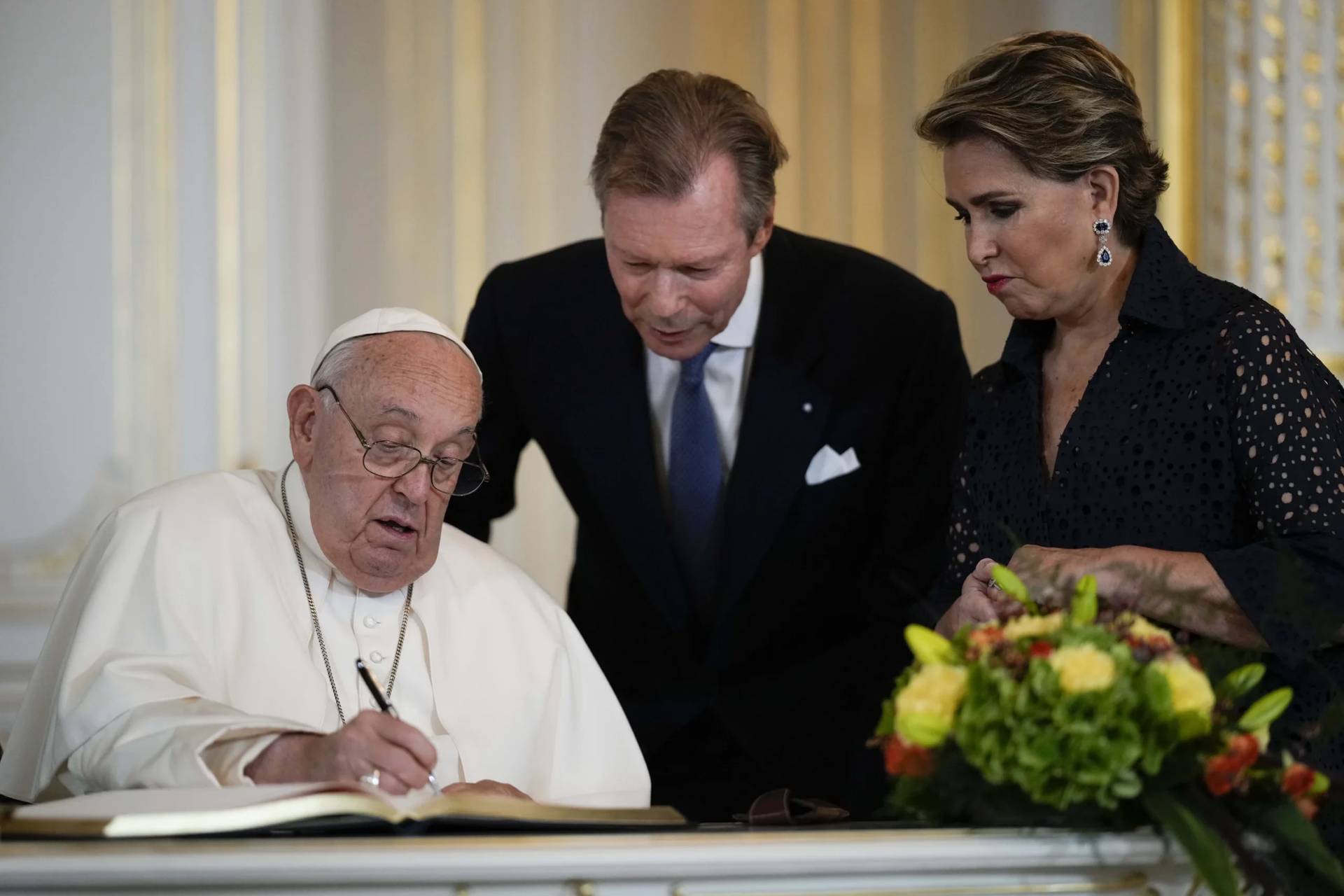 Pope Francis flanked by Luxembourg’s Grand Duke Henri and Grand Duchess Maria Teresa signs the guest book during his visit at the Grand Ducal Palace, in Luxembourg, Thursday, Sept. 26, 2024. (Credit: Andrew Medichini/AP.)