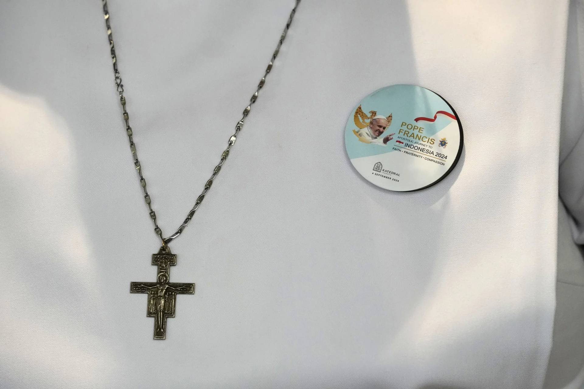 A nun wears a crucifix and a badge showing Pope Francis as she waits for the Pope’s arrival in the Cathedral of Our Lady of the Assumption, the capital’s main Catholic cathedral, in Jakarta, Indonesia, Wednesday, Sept. 4, 2024. (Credit: Dita Alangkara/AP.)