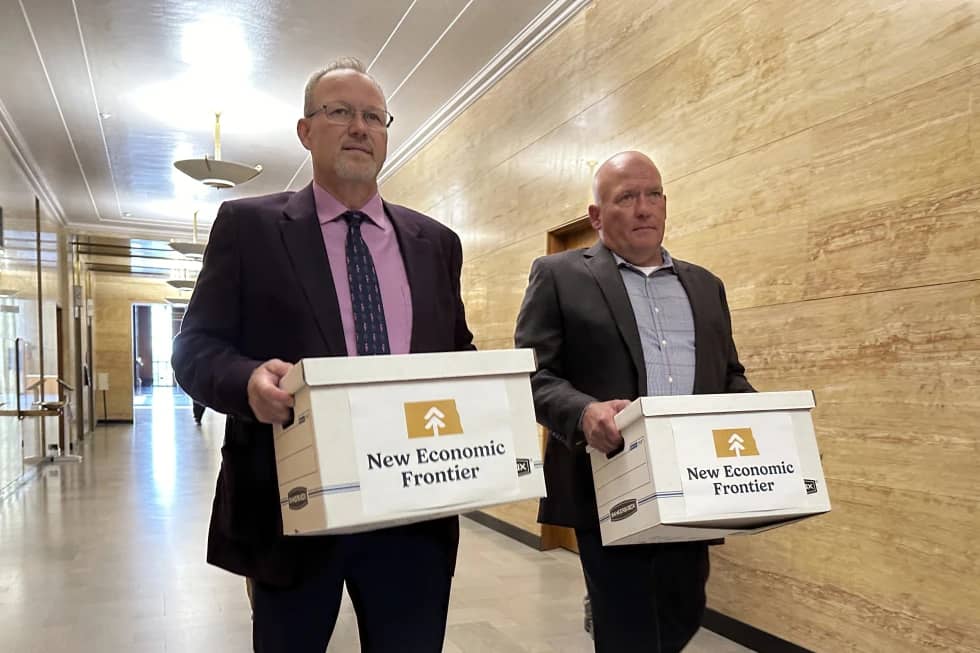 Steve Bakken, left, and Casey Neumann, of the New Economic Frontier ballot initiative group, carry boxes containing petitions to the Secretary of State’s Office on Monday, July 8, 2024, at the state Capitol in Bismarck, N.D. (Credit: Jack Dura/AP.)