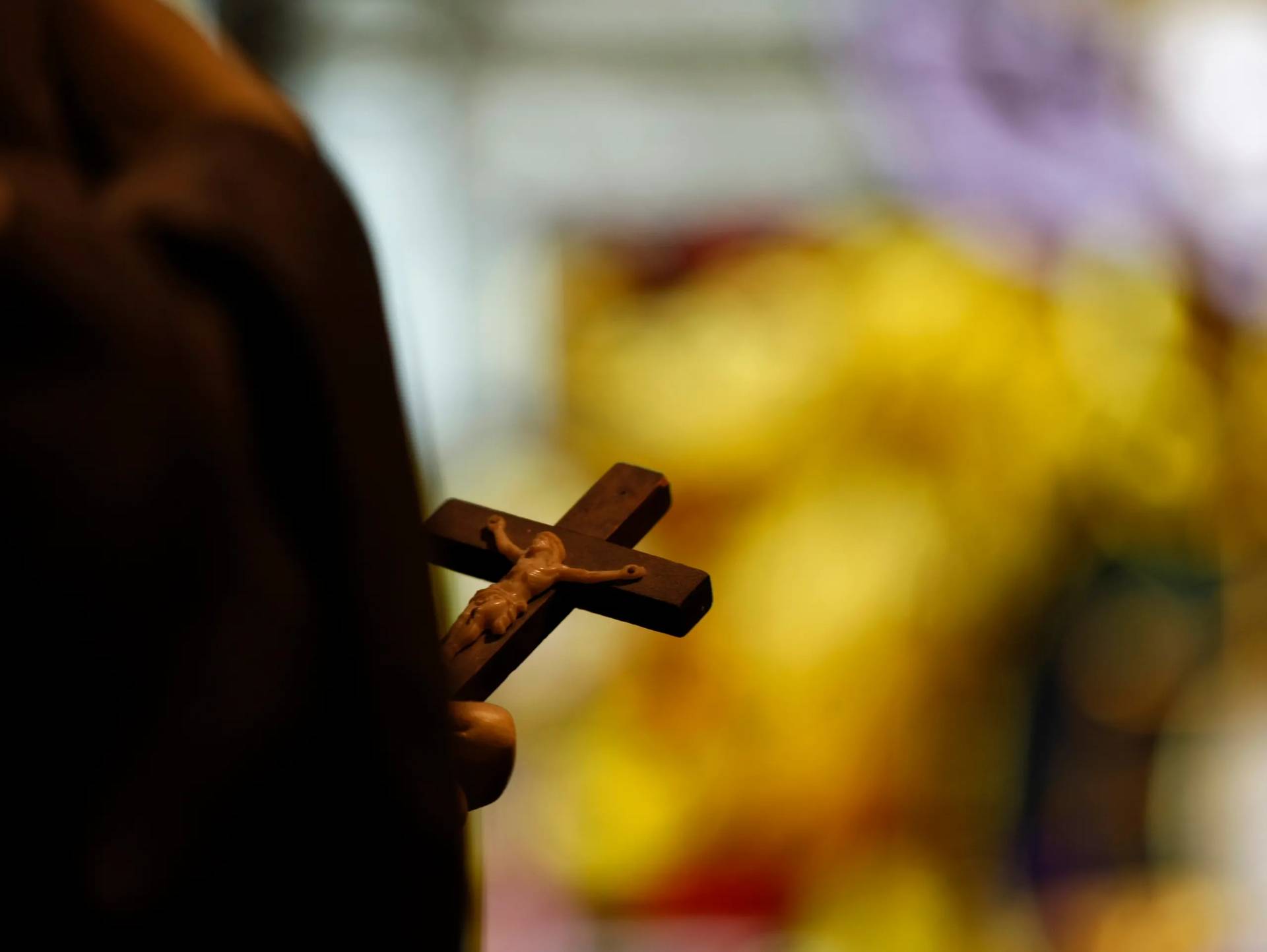 In this Dec. 1, 2012 photo, a statue with a crucifix and a stained glass window is seen inside a Catholic Church in New Orleans. (Credit: Gerald Herbert/AP.)