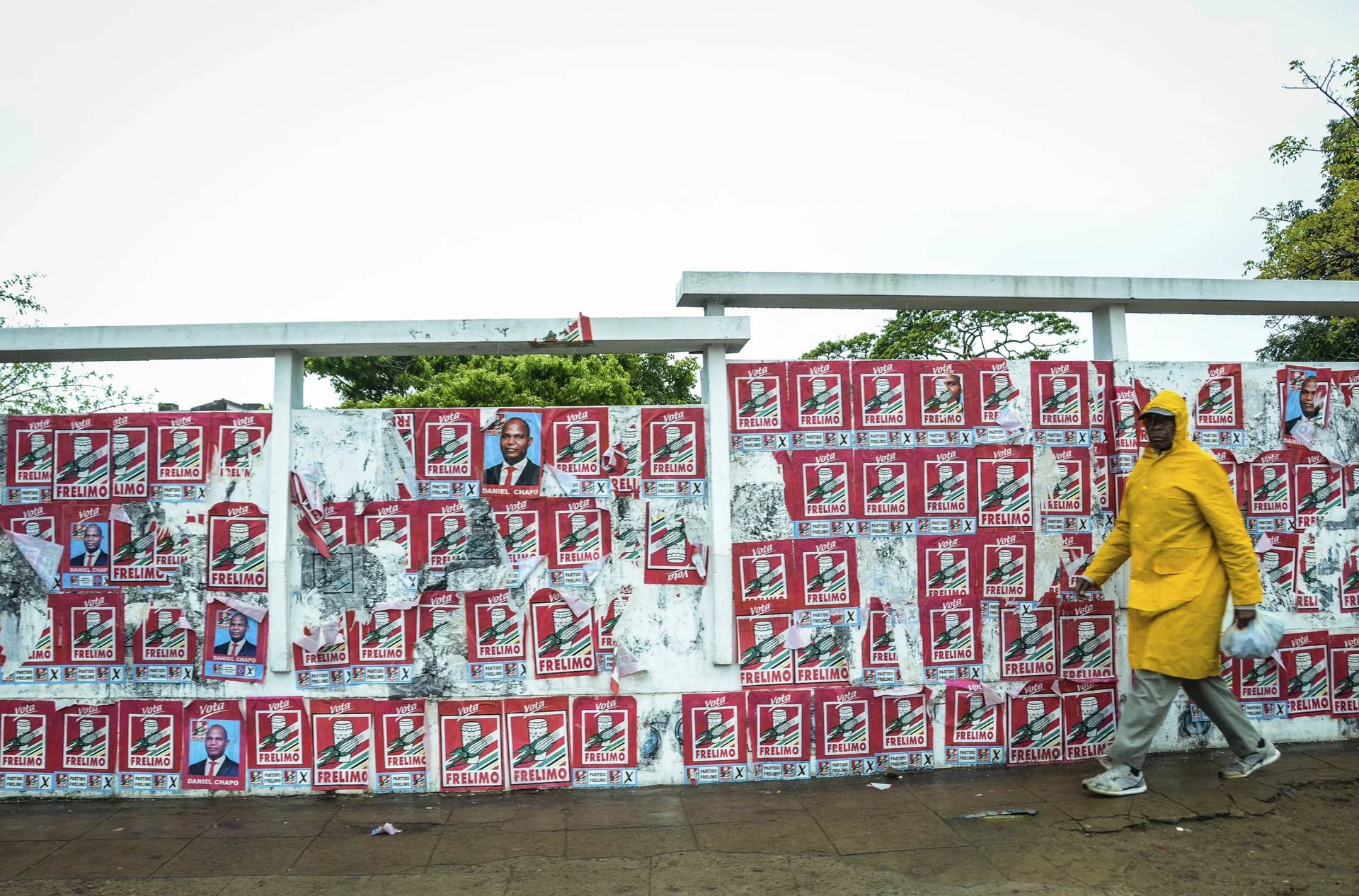 A pedestrian passes a wall of election posters in Maputo, Sunday, Oct. 6, 2024, ahead of elections to be held in Mozambique. (Credit: Carlos Uqueio/AP.)