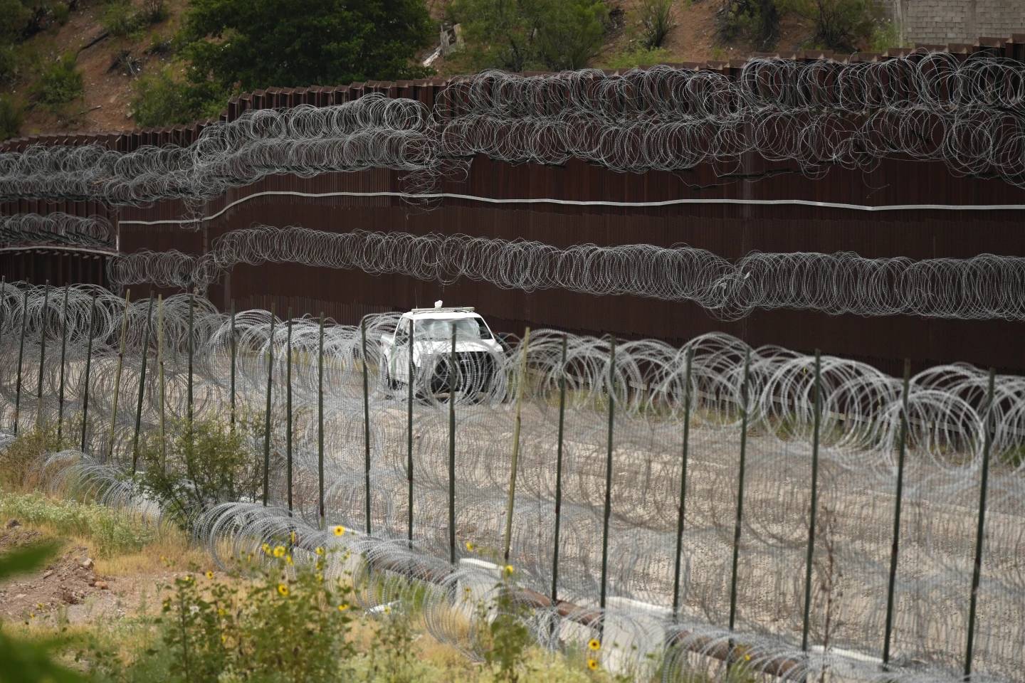 A vehicle drives along the U.S. side of the US-Mexico border wall in Nogales, Ariz., June 25, 2024. (Credit: Associated Press.)