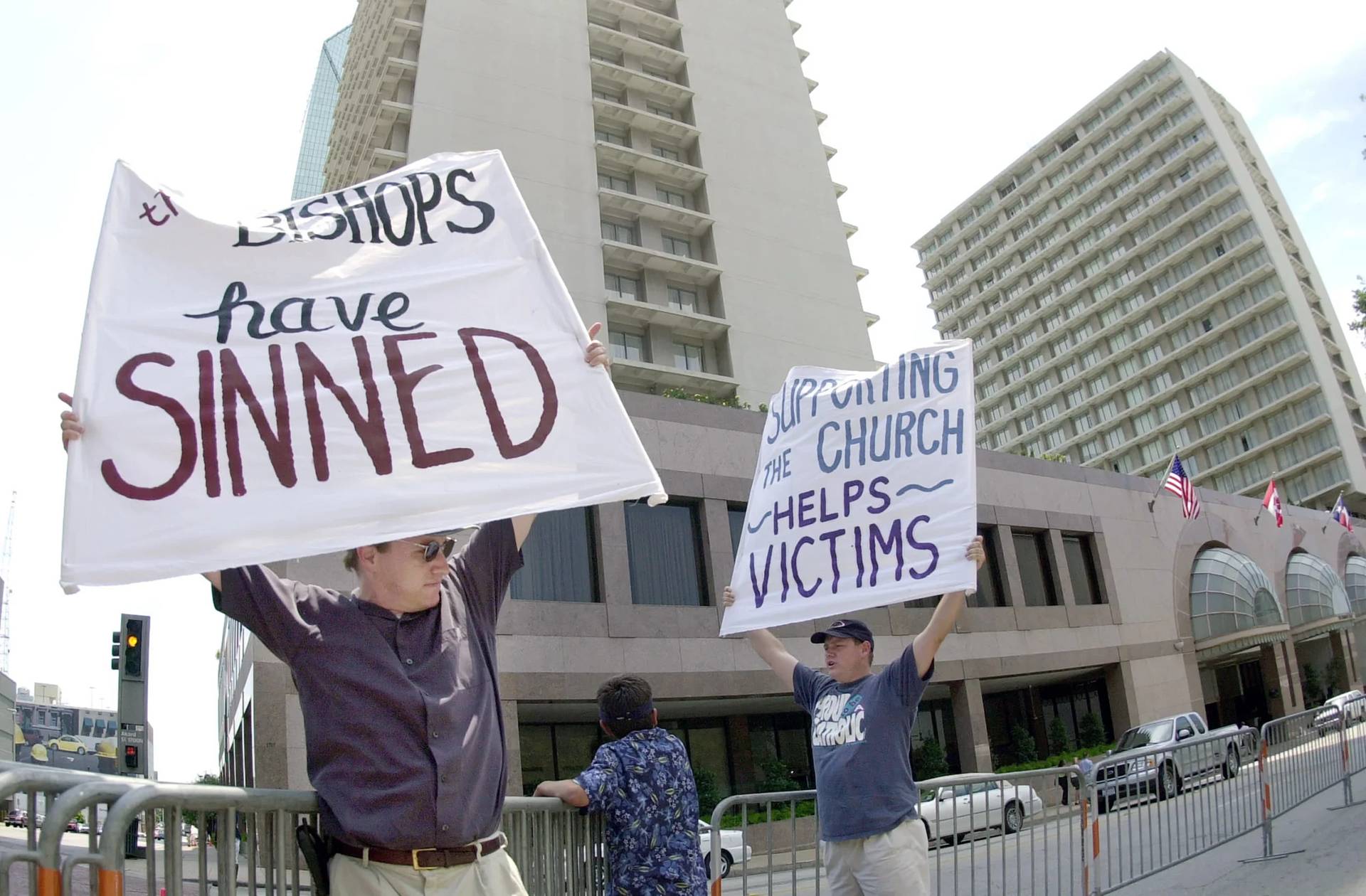 Dave West, left, and his brother Larry West, both of Fort Worth, Texas, demonstrate outside the hotel where the U.S. Conference of Catholic Bishops are meeting in Dallas on June 14. 2002. (Credit: Charlie Riedel/AP.)