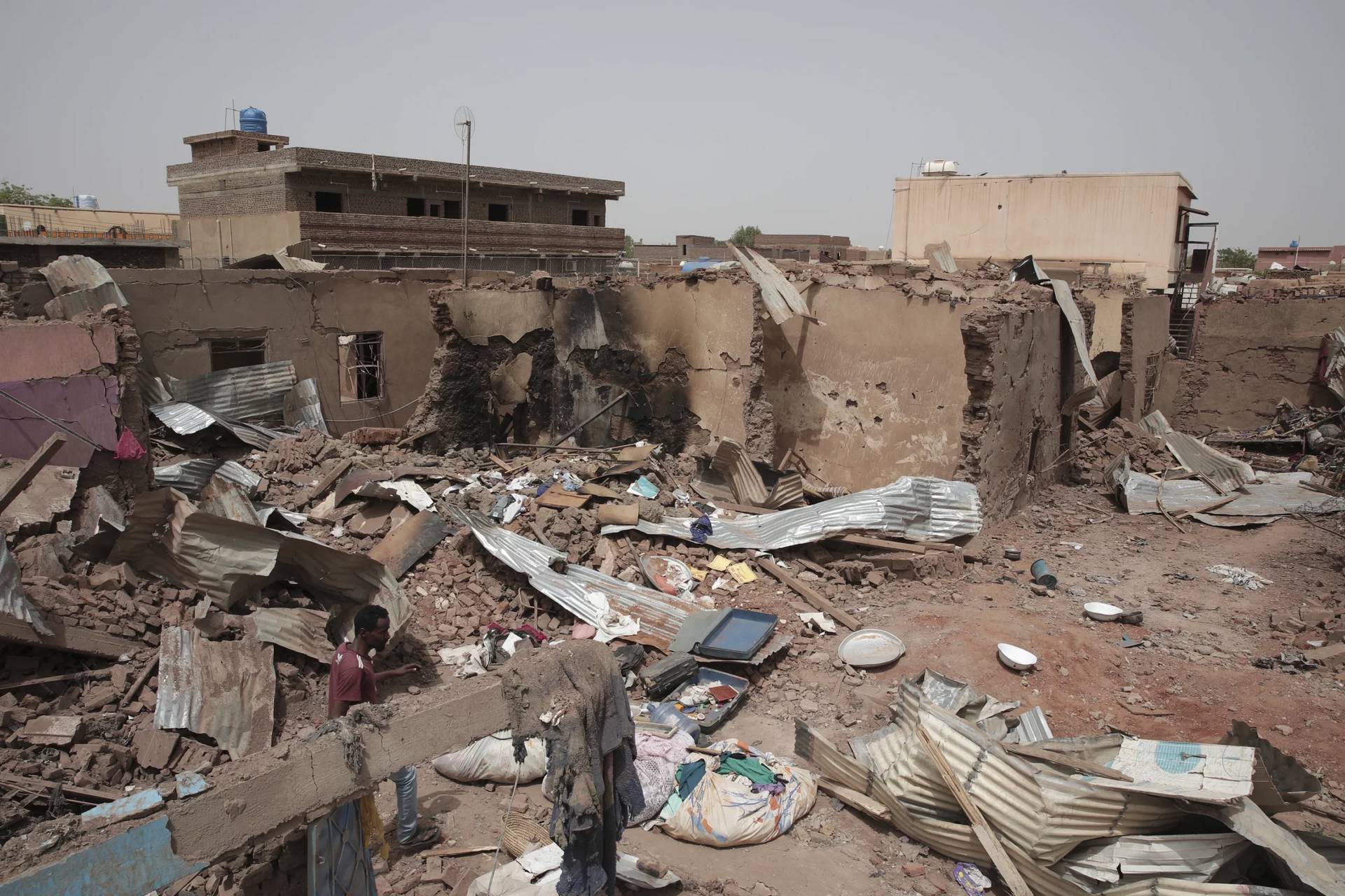 A man walks by a house hit in recent fighting in Khartoum, Sudan, an area torn by fighting between the military and the notorious paramilitary Rapid Support Forces, April 25, 2023. (Credit: Marwan Ali/AP.)