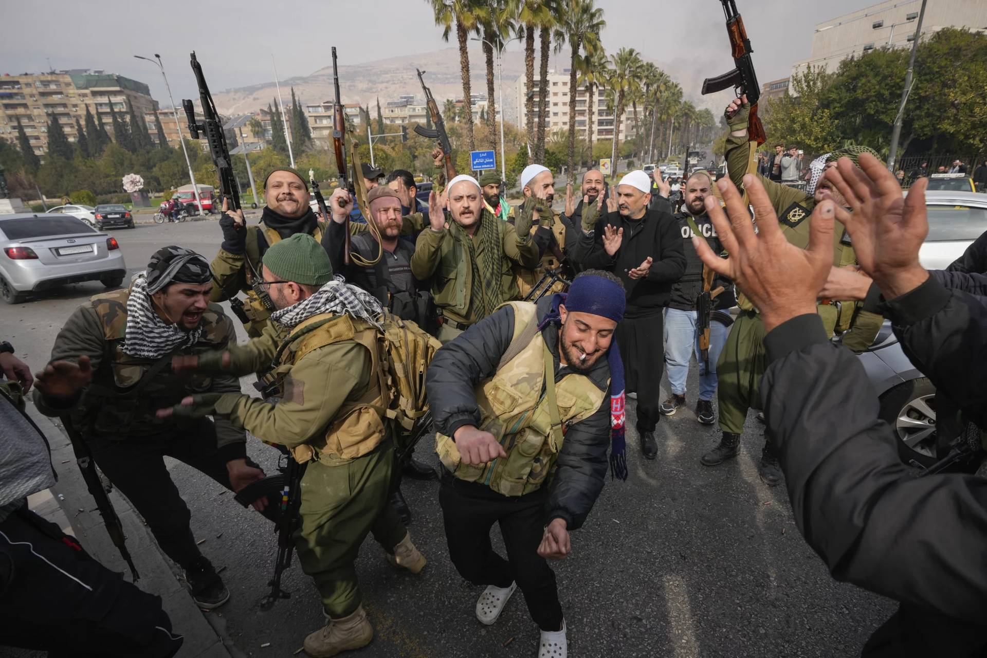 Opposition fighters celebrate in Damascus, Syria, Sunday Dec. 8, 2024. (Credit: Hussein Malla/AP.)