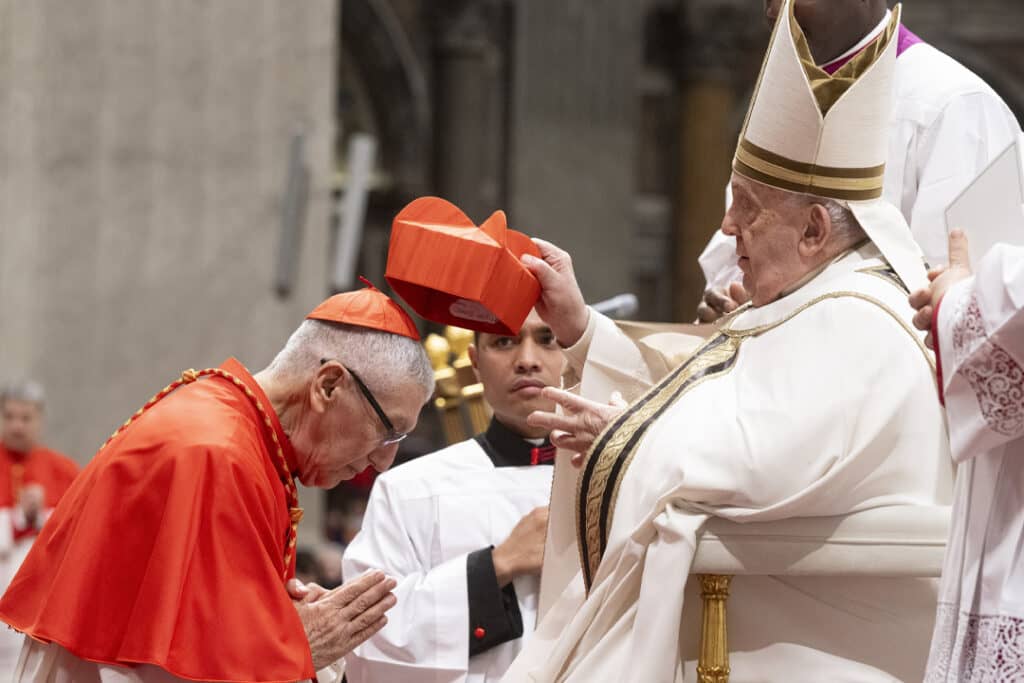 Pope Francis places the red biretta on the head of Cardinal Carlos Castillo, archbishop of Lima, during a Dec. 7 consistory for the creation of new cardinals inside St. Peter's Basilica. (Credit: Vatican Media.)