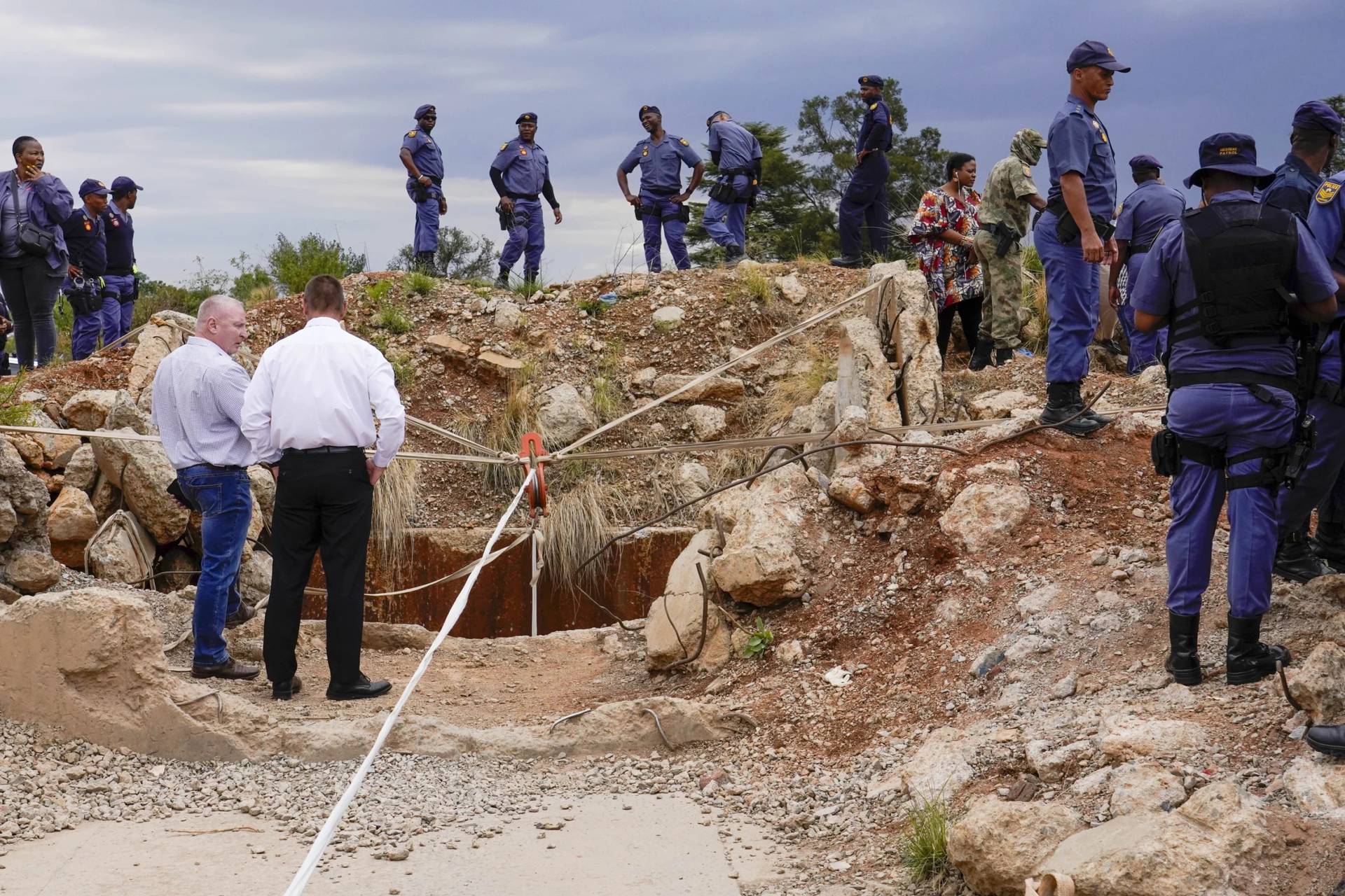 Police officers and private security workers stand by a mine shaft in Stilfontein, South Africa, on Nov. 15, 2024. (Credit: Denis Parrell/AP.)