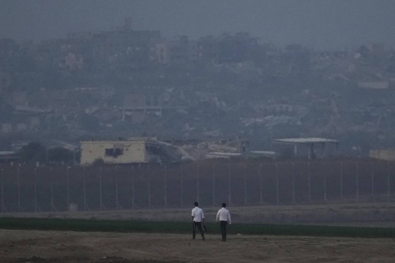 Two men walk near the border with Gaza in southern Israel on Thursday, Jan. 16, 2025. (Credit: Ariel Schalit/AP.)