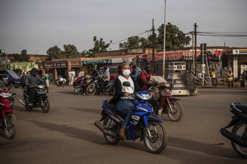 People ride their scooters in the Gounghin district of Ouagadougou in Burkina Faso on Jan. 26, 2022. (Credit: Sophie Garcia/AP.)