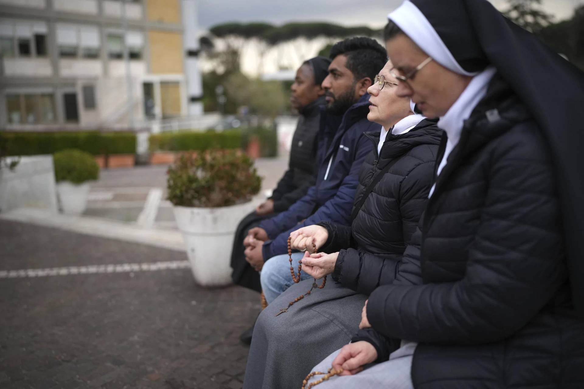 Nuns pray for Pope Francis in front of the statue of Pope John Paul II at the Agostino Gemelli Polyclinic, in Rome, Thursday, Feb. 20, 2025, where the Pontiff is hospitalized since Friday, Feb. 14. (Credit: Alessandra Tarantino/AP.)