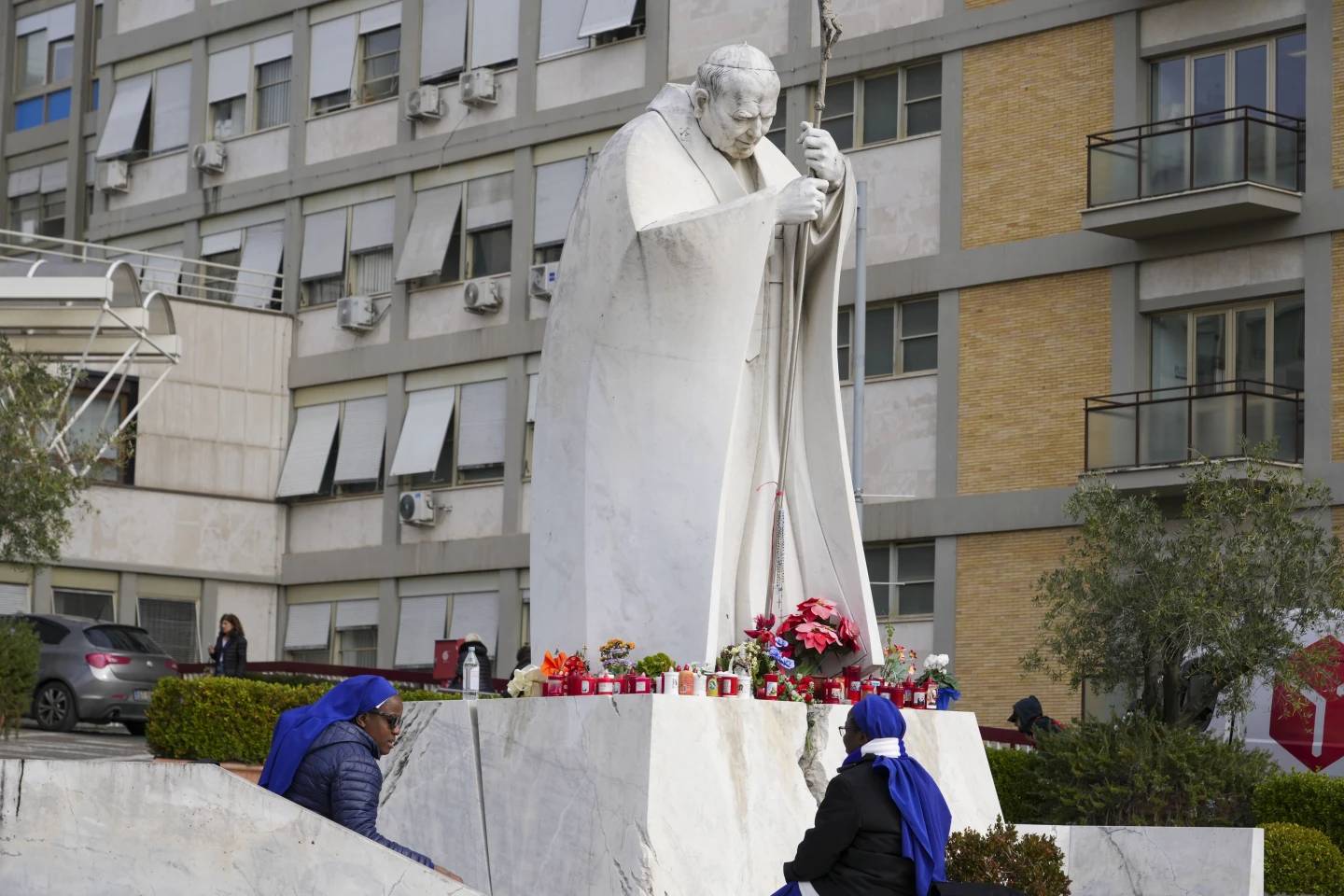 Nuns pray in front of a statue of Pope John Paul II in front of the Gemelli Hospital in Rome on Feb. 17, 2025. (Credit: Andrew Medichini/AP.)