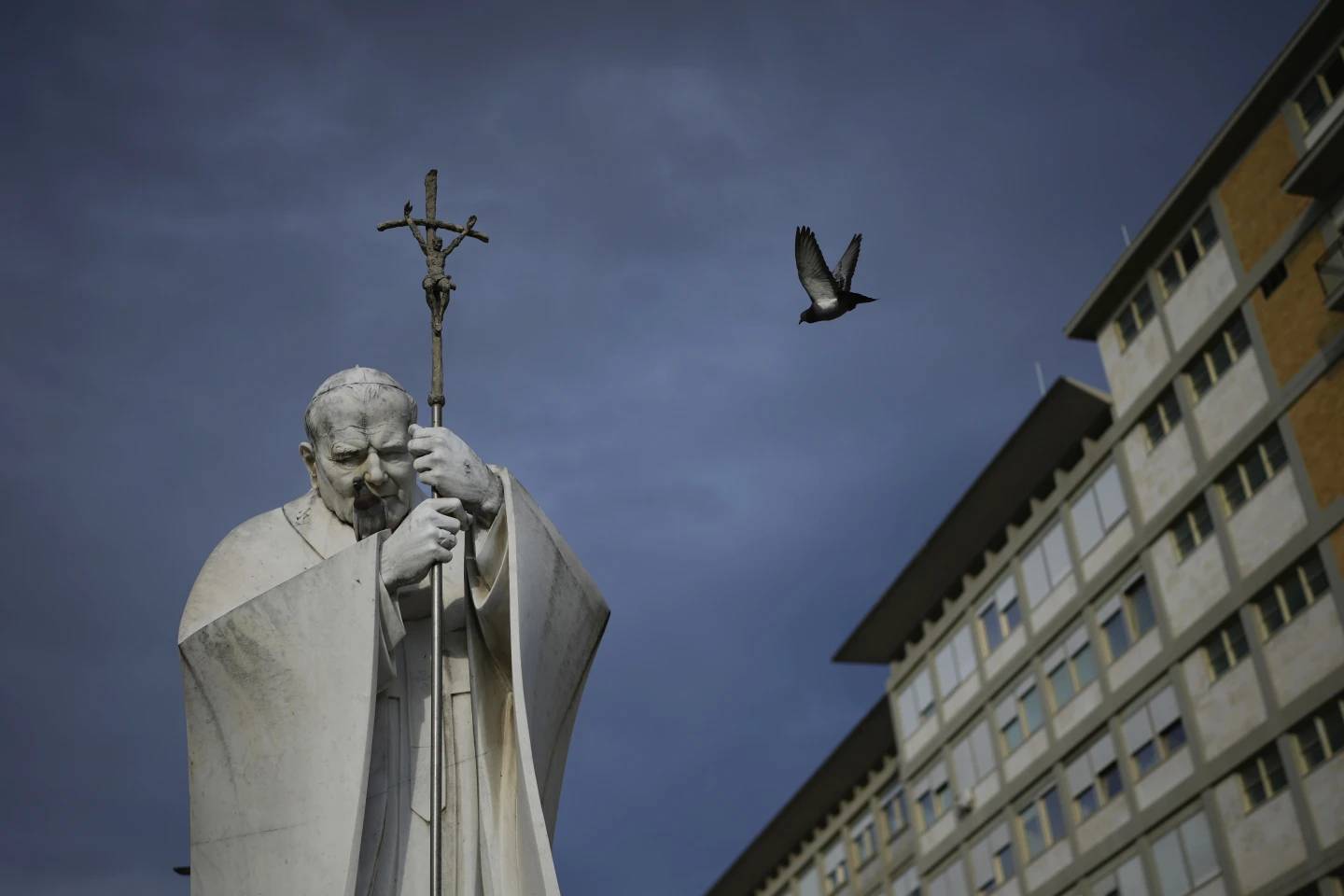 A marble statue of Pope John Paul II is backdropped by Gemelli Hospital in Rome on Saturday, Feb. 15, 2025. (Credit: Alessandra Tarantino/AP.)