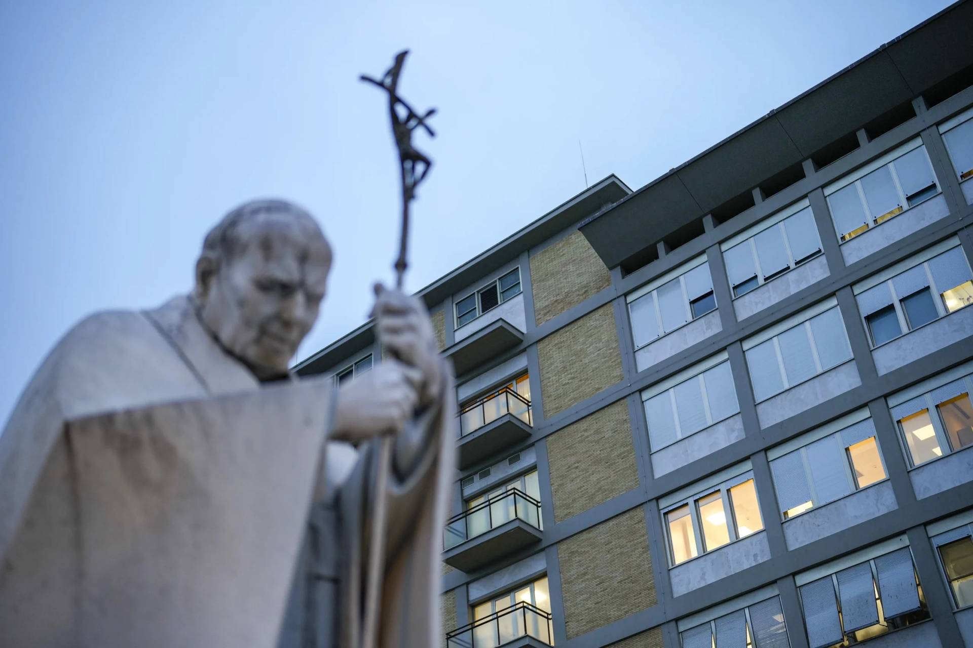 A marble statue of the late Pope John Paul II is backdropped by the Gemelli Hospital in Rome on Saturday, Feb. 15, 2025. (Credit: Gregorio Borgia/AP.)