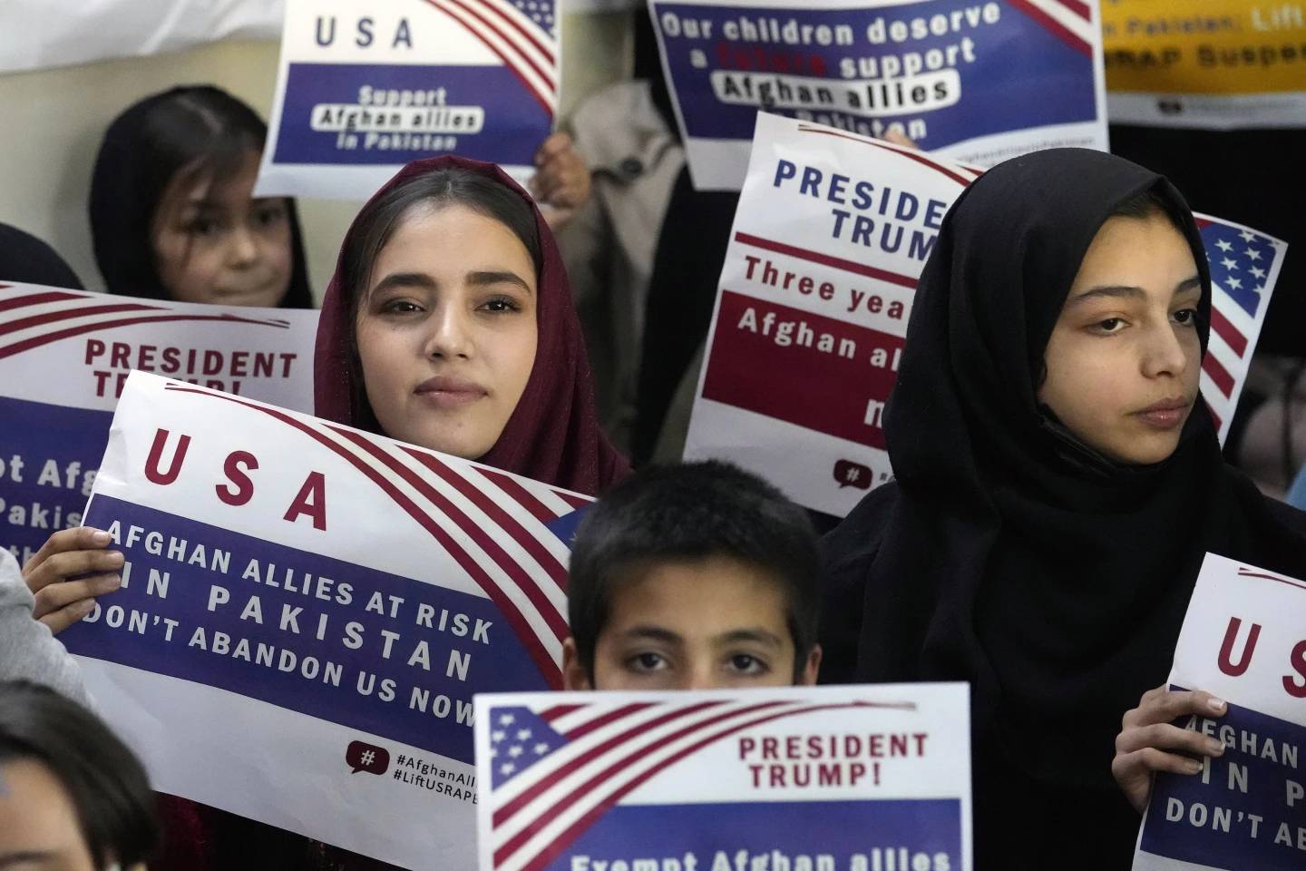 Afghan refugees hold placards during a meeting to discuss their situation after President Donald Trump paused U.S. refugee programs, in Islamabad, Pakistan, Jan. 24, 2025. (Credit: Anjum Naveed/AP.)