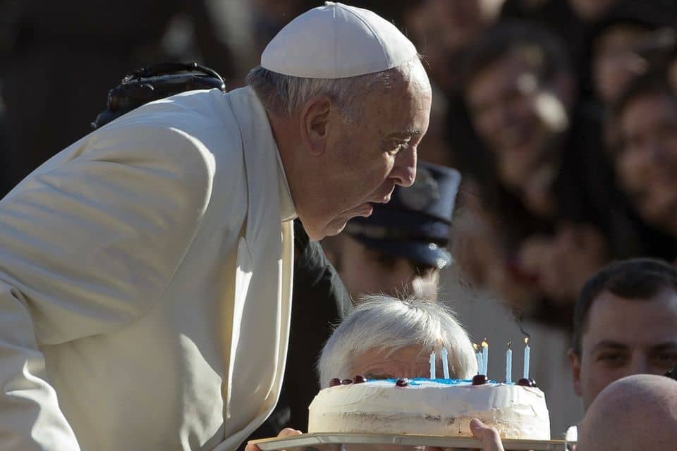 Pope Francis blows candles on a birthday cake during a Dec. 17, 2014, general audience in St. Peter's Square. (Credit: AP Photo.)