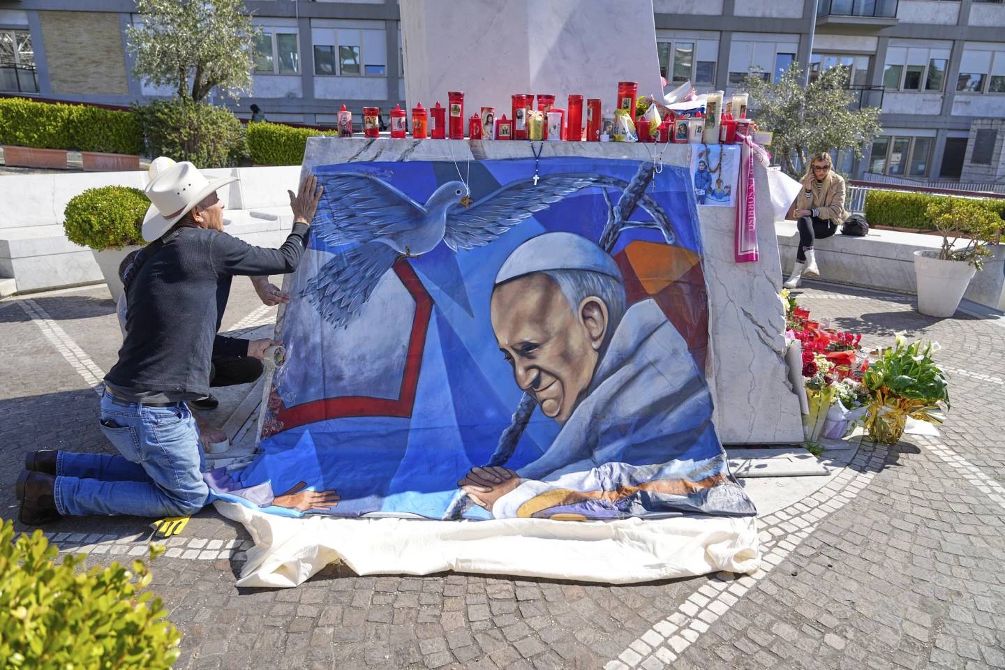 Mexican painter Roberto Marquez places a painting of Pope Francis he made outside the Gemelli Hospital in Rome on Wednesday, March 5, 2025. (Credit: Credit: Gregorio Borgia/AP.)