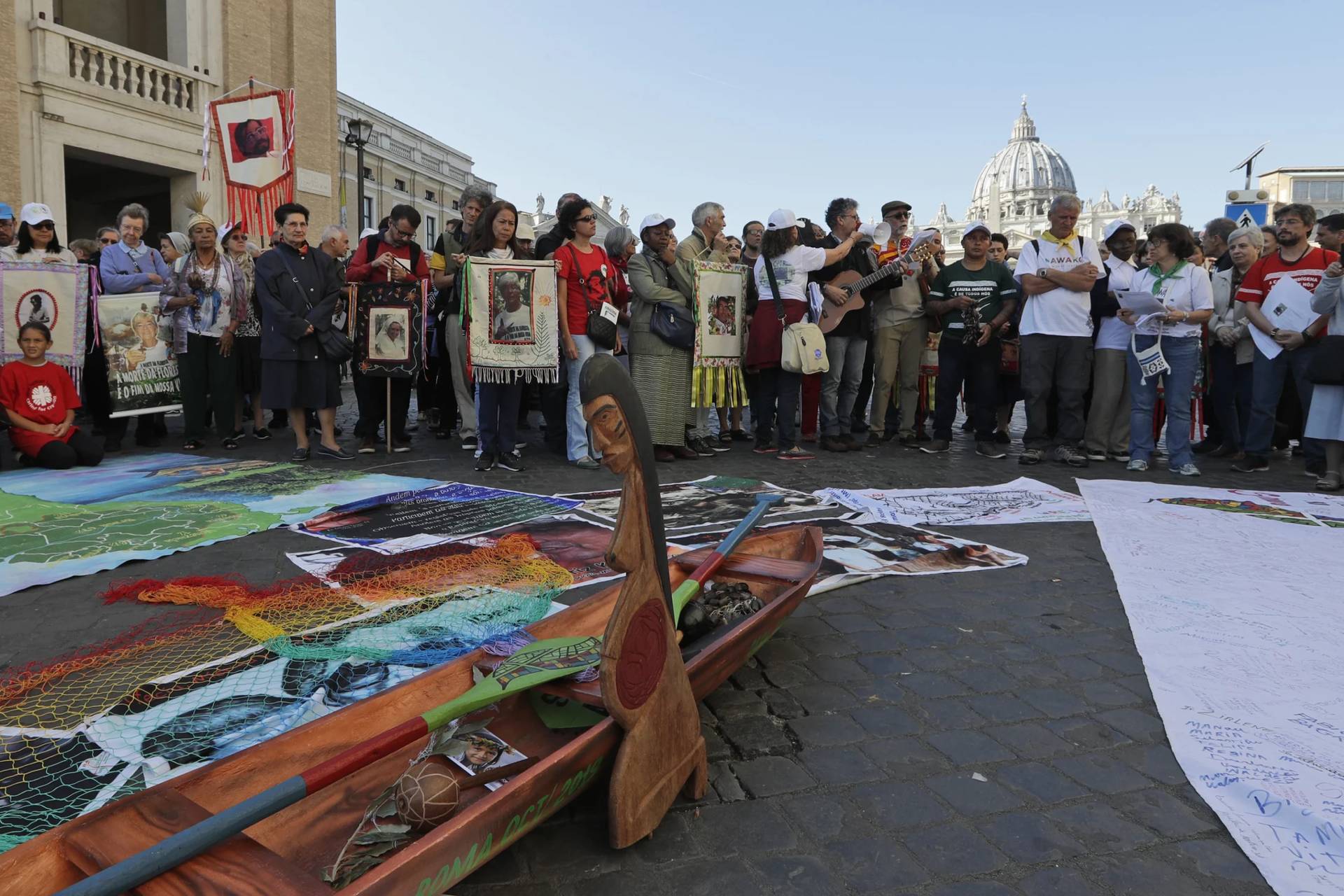 A wooden statue of a prengant woman in front of Amazonian members outside the Vatican on Oct. 19, 2019. (Credit: Andrew Medichini/AP.)