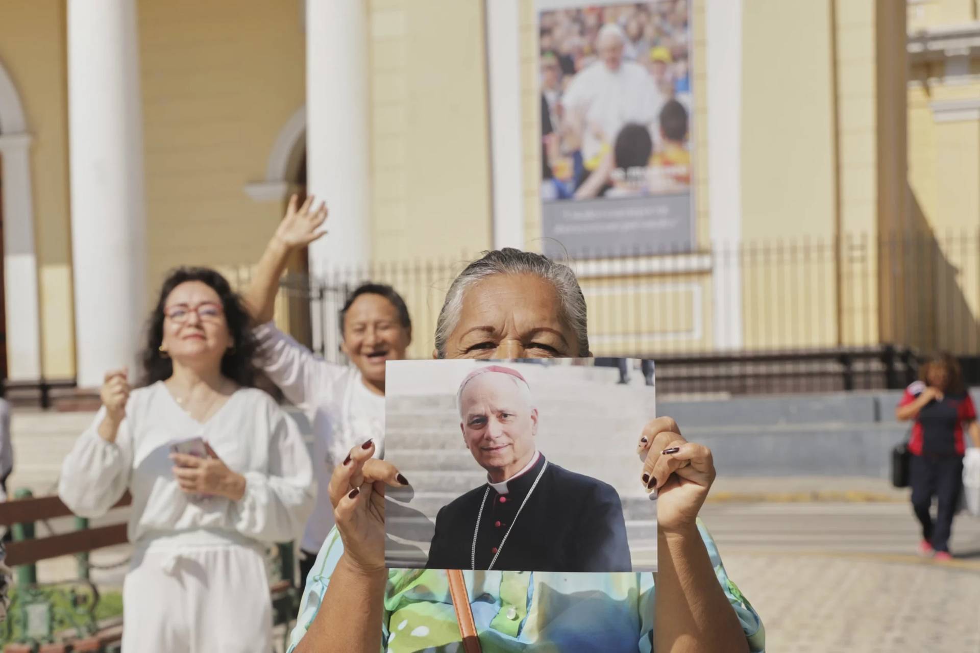 A woman holds a picture of Bishop Robert Prevost, the man who became Pope Leo XIV, in front of the Cathedral of Chiclayo, Peru, on May 8, 2025. (Credit: Manuel Medina/AP.)