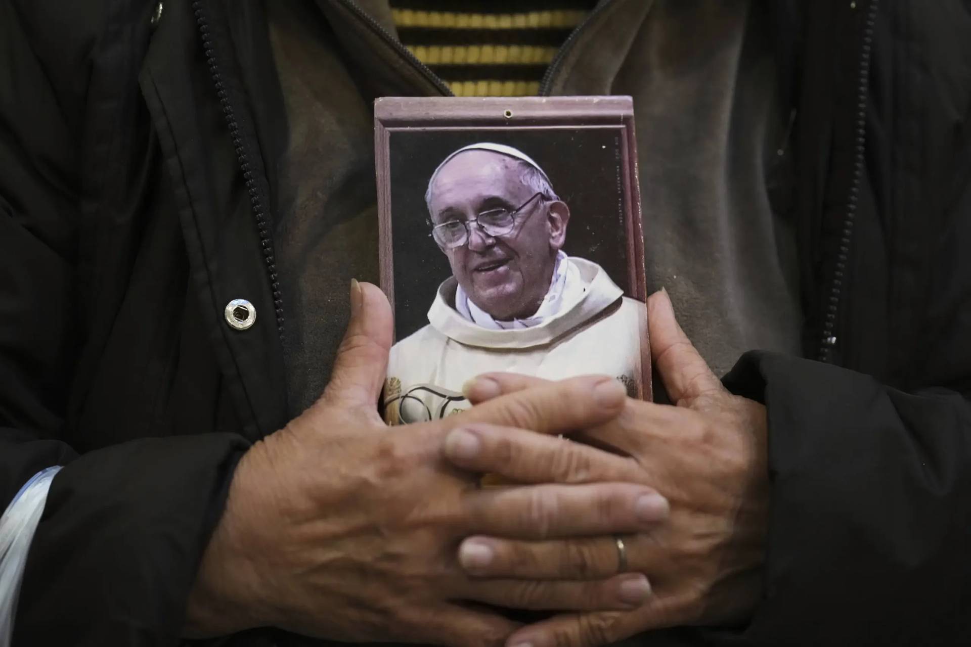 A person holds a picture of Pope Francis at the Basilica de San Jose de Flores in Buenos Aires, Argentina, on April 21, 2025. (Credit: Gustavo Garello/AP.)