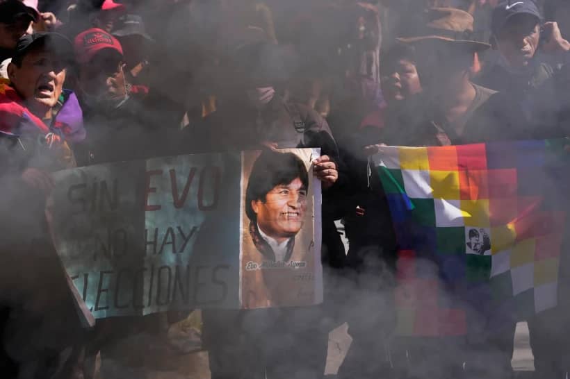 Supporters hold a sign with an image of former President Evo Morales and a message that reads in Spanish, “Without Evo, there are no elections,” during a protest demanding he be allowed to compete in the upcoming presidential election, near the Supreme Electoral Tribunal in La Paz, Bolivia, Thursday, May 29, 2025. (Credit: Juan Karita/AP.)
