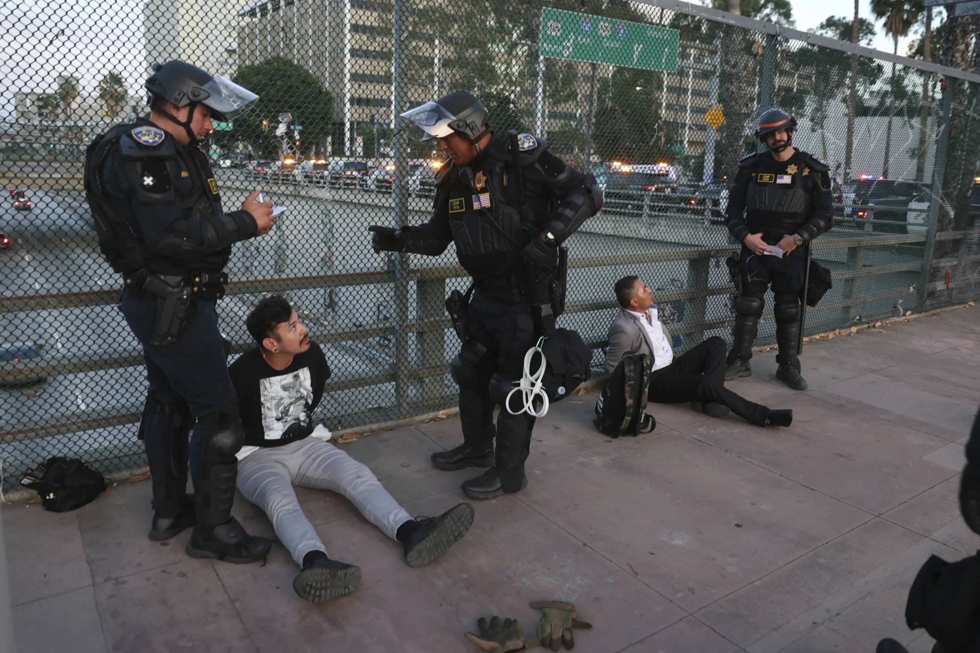 California Highway Patrol officers arrest two men after a dispersal order during a protest Saturday, June 14, 2025, in Los Angeles. (Credit: Ethan Swope/AP.)