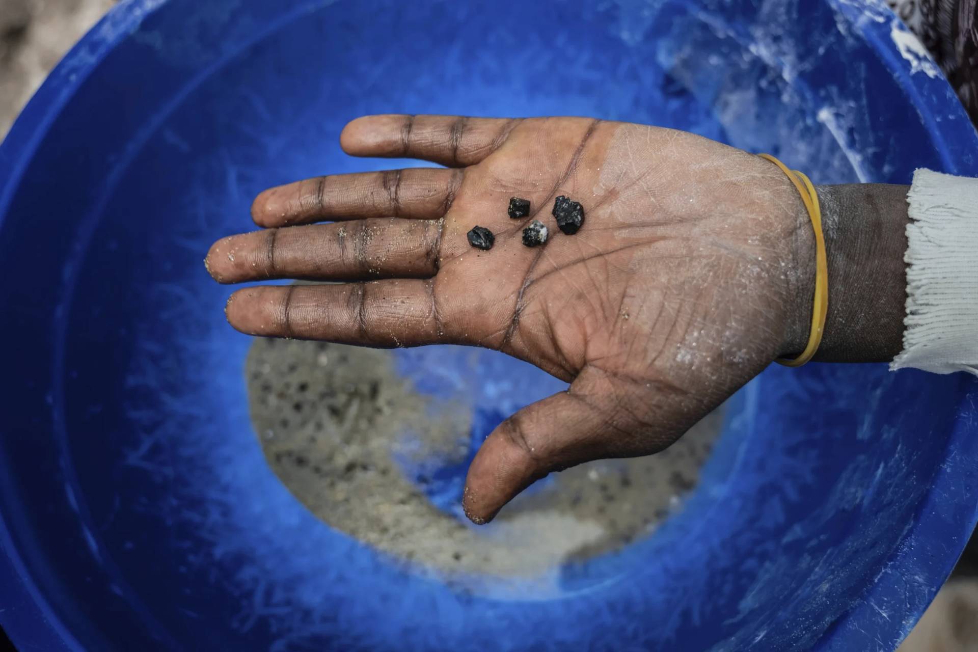 A mine worker holds bits of coltan ore in the mining town of Rubaya in the Democratic Republic of Congo on May 9, 2025. (Credit: Moses Sawasawa/AP.)