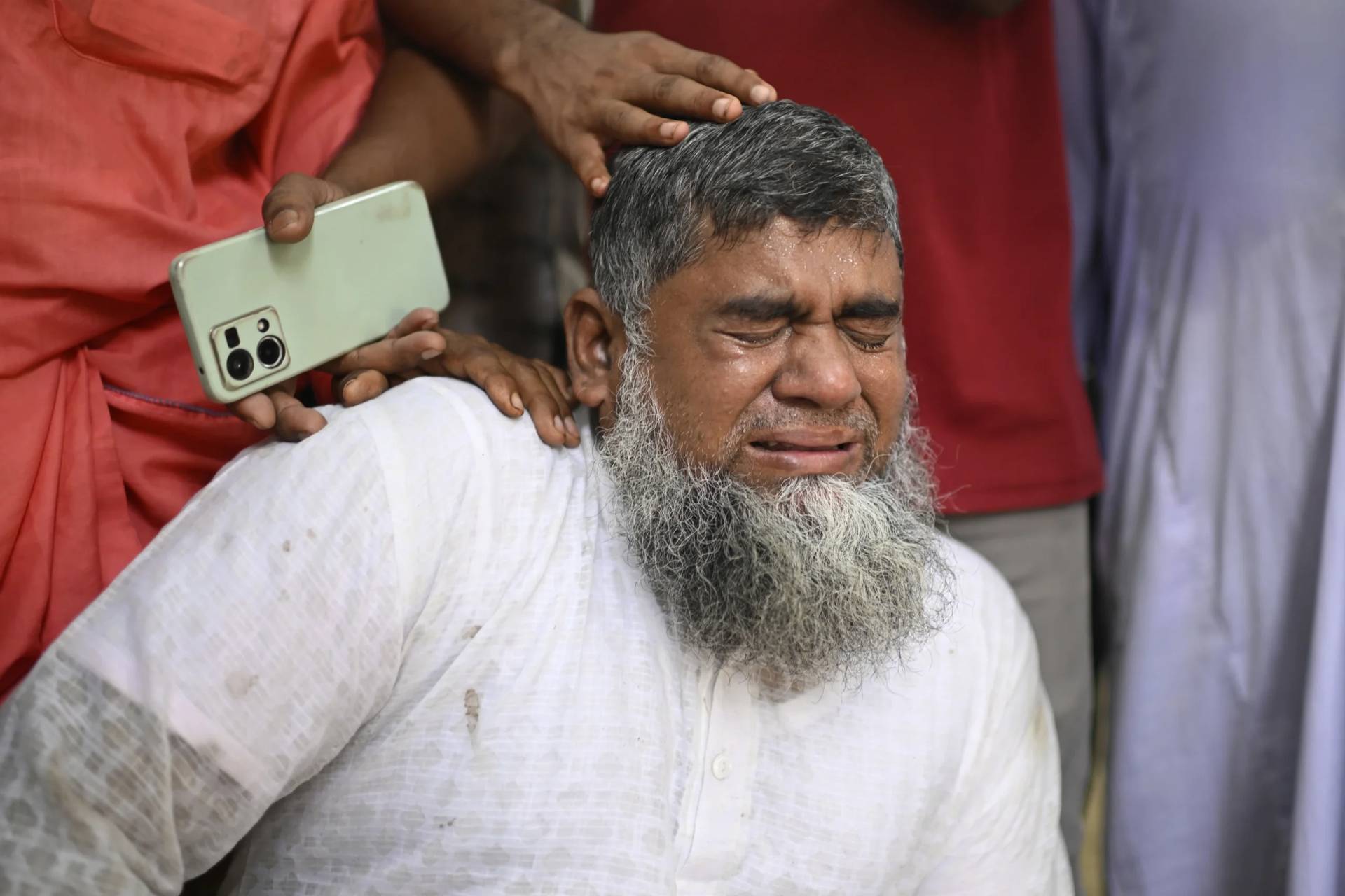 Shahbul, father of a missing girl student, cries after a Bangladesh Air Force training aircraft that crashed onto a school campus shortly after takeoff in Dhaka, Bangladesh, Monday, July 21, 2025. (Credit: Mahmud Hossain Opu/AP.)
