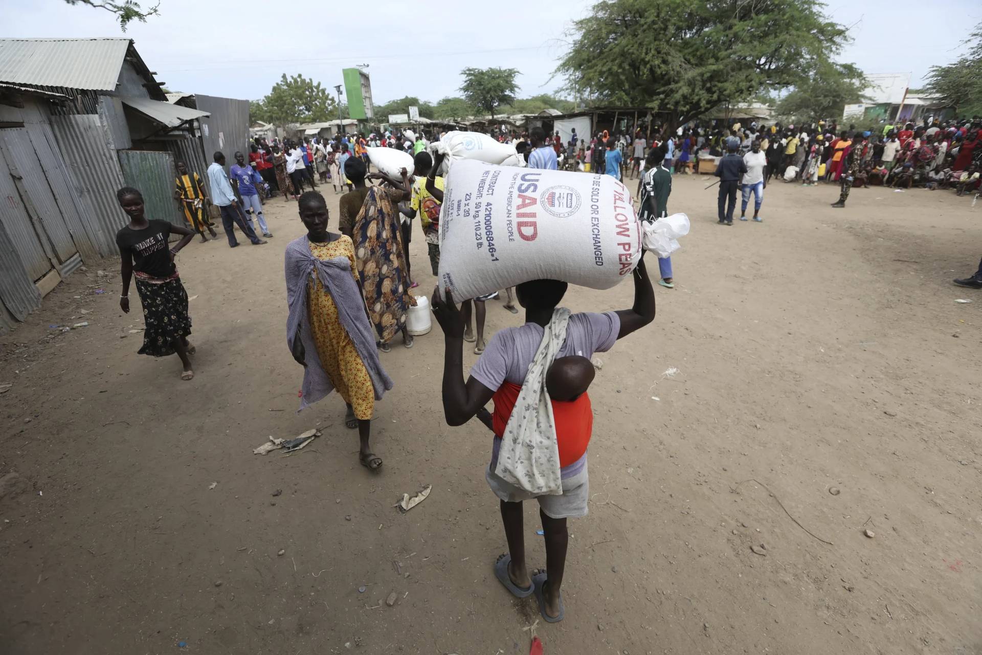 Refugees carry food at a distribution center run by the World Food Programme (WFP) at Kakuma Refugee Camp in Turkana, Kenya Tuesday, June 3, 2025. (Credit: Andrew Kasuku/AP.)