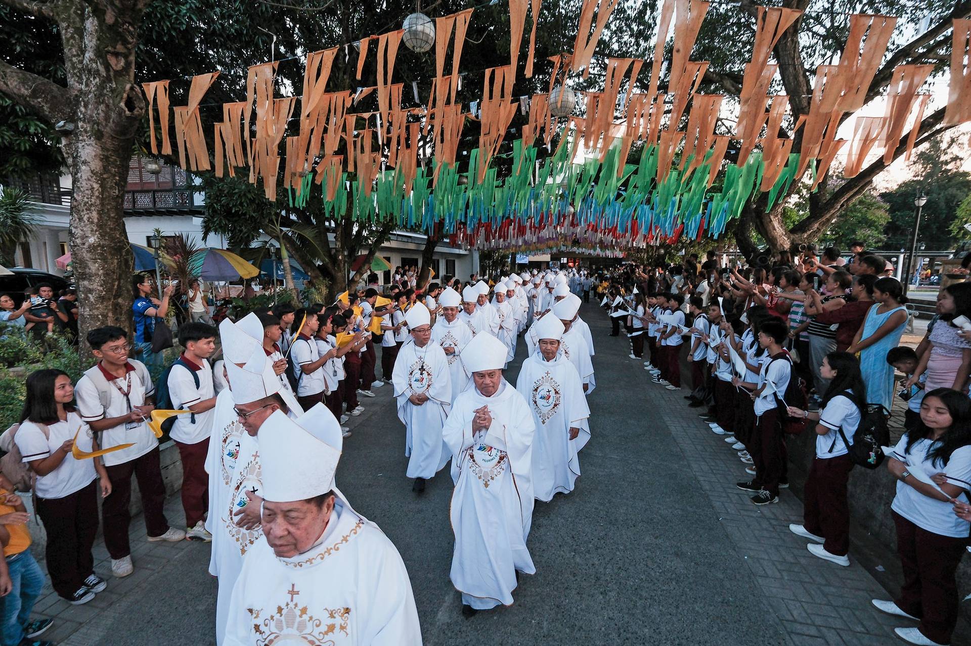Welcomed by locals holding colorful flags, Filipino bishops join the procession to Saint Michael the Archangel Parish in Jagna, Bohol, in the central Philippines, for a Mass on the first day of their 130th plenary assembly, July 5, 2025. (Credit: CBCP News.)