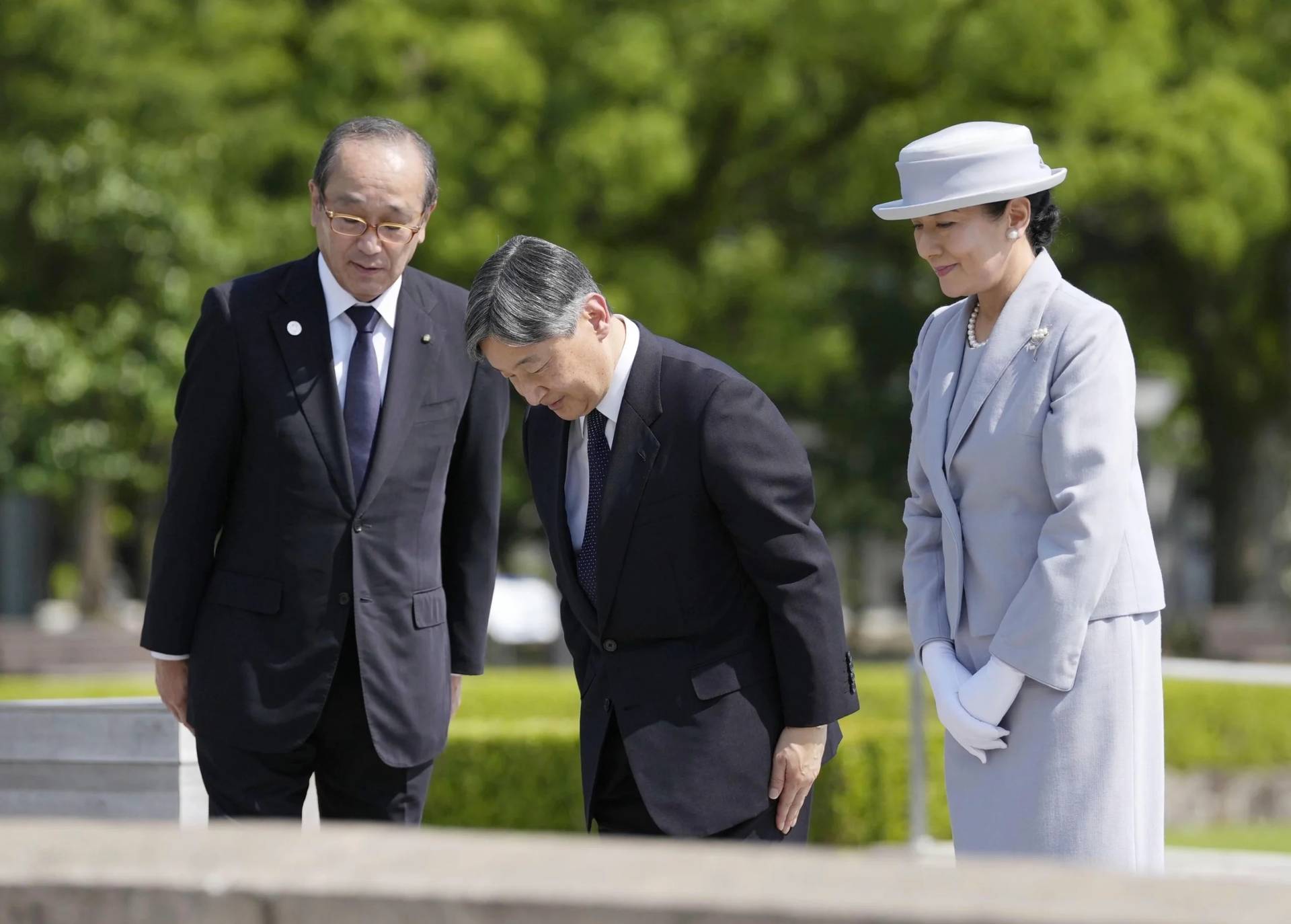 Japanese Emperor Naruhito, center, and Empress Masako bow in front of the cenotaph dedicated to the victims of the atomic bombing as they visit the Peace Memorial Park in Hiroshima, western Japan Thursday, June 19, 2025. Hiroshima Mayor Kazumi Matsui is at left. (Credit: Kai Naito/Kyodo News via AP.)