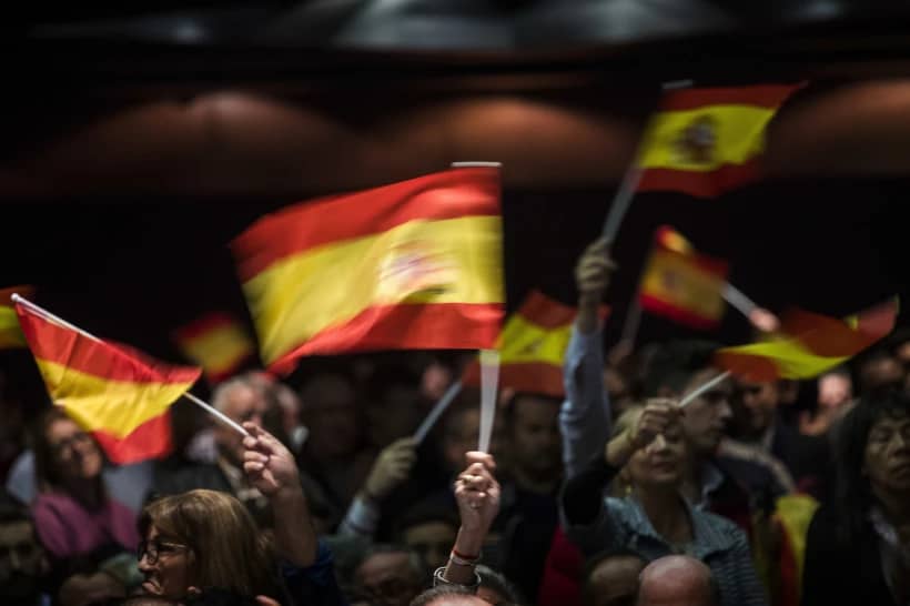 Supporters of Spain’s far-right Vox party wave flags during a rally in Murcia, Spain, Wednesday Nov. 14, 2018. (Credit: Emilio Morenatti/AP.)